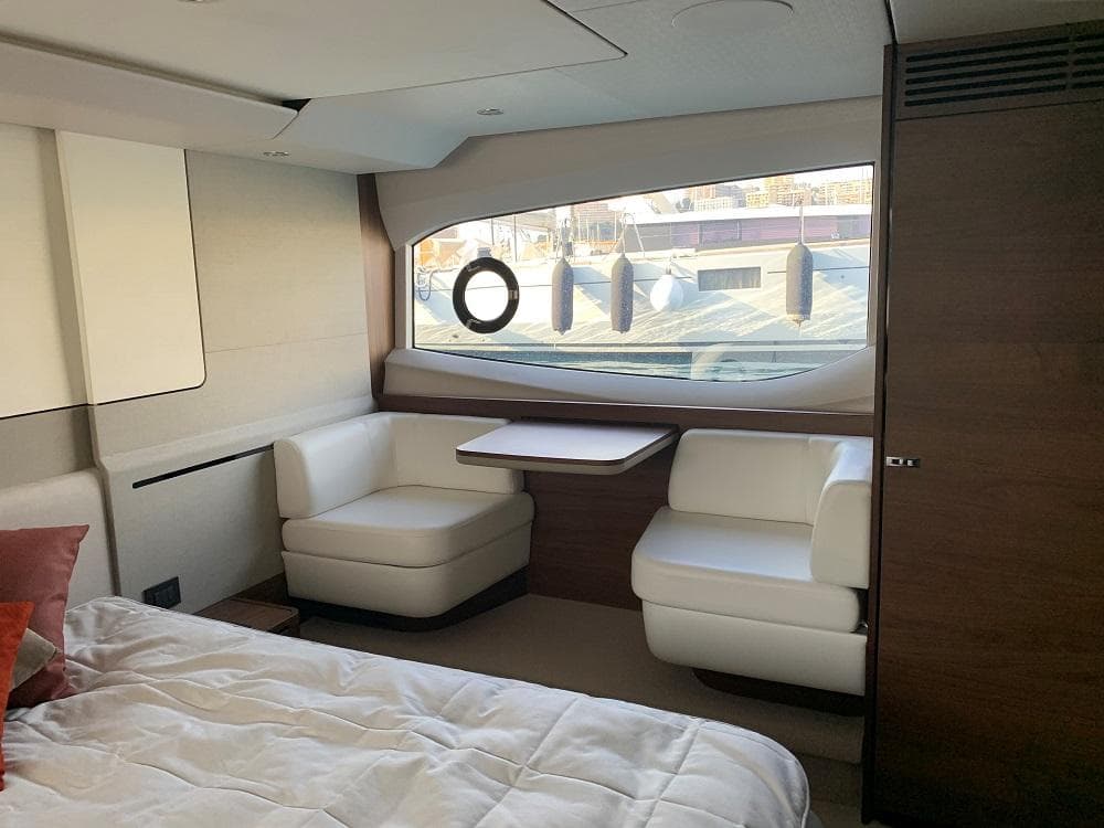 Luxurious interior of 2020 Princess F62 yacht with elegant seating and large window.