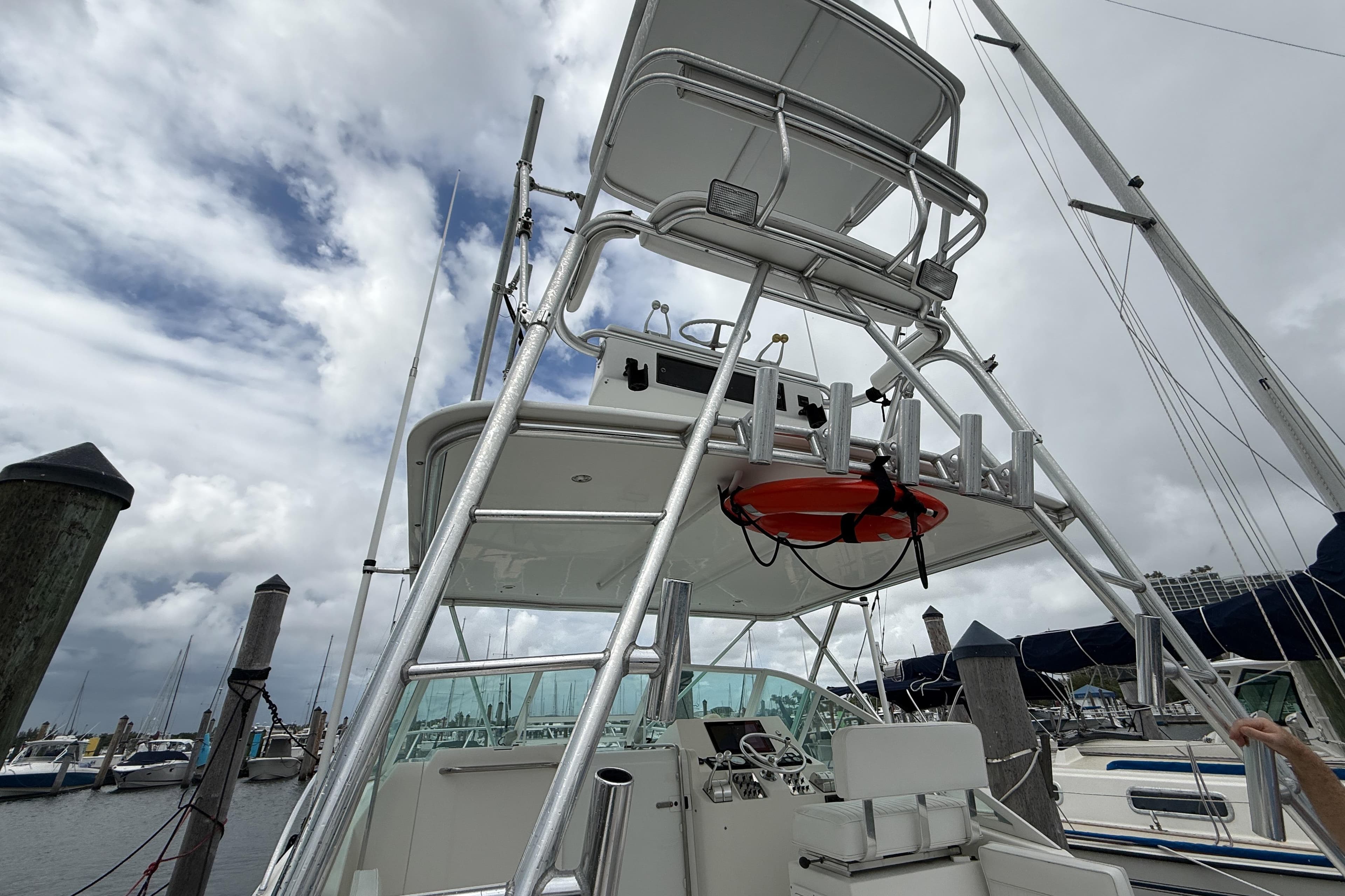 1998 Cabo 31 Express boat with tower, docked under cloudy skies.