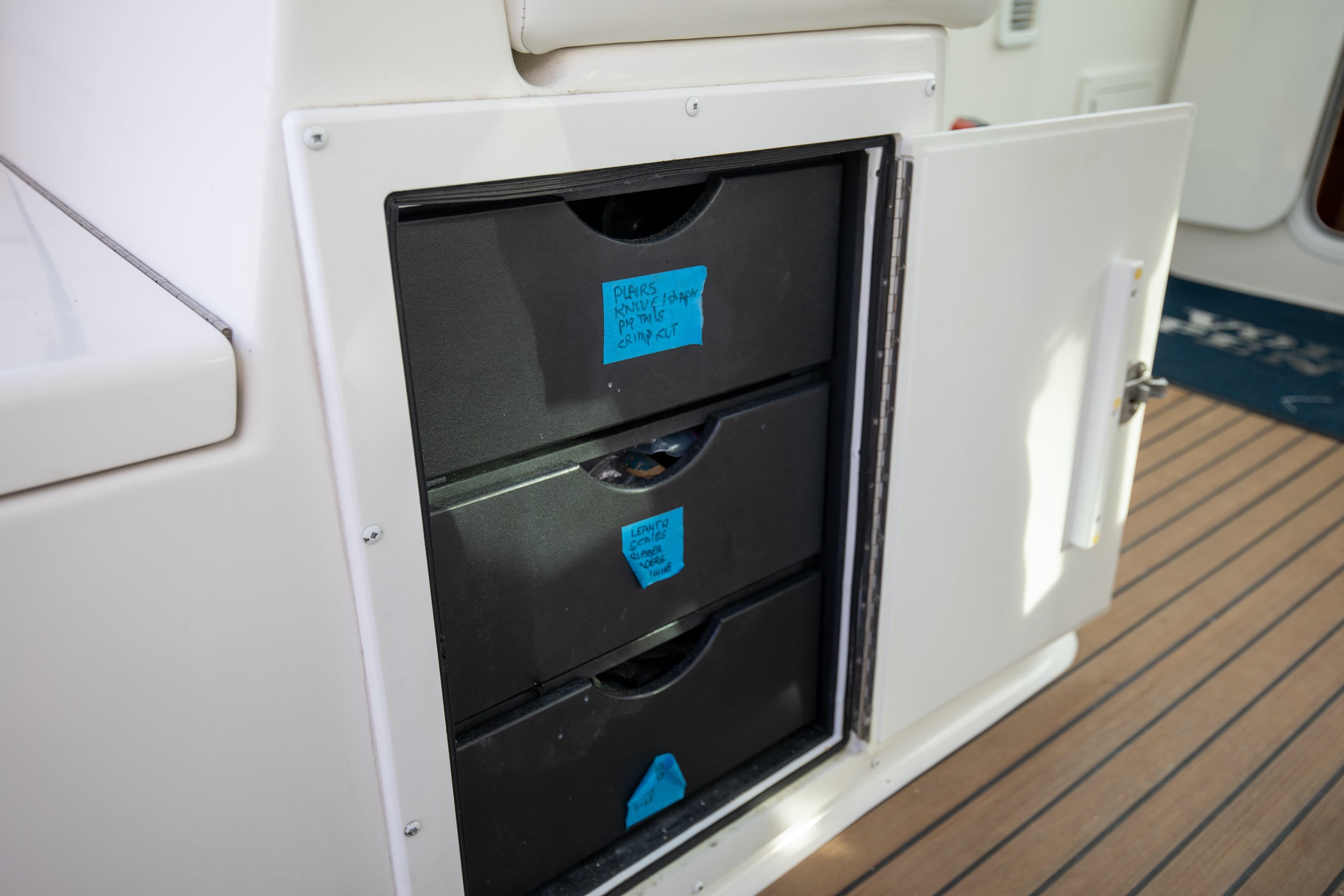 Storage drawers on a 2015 Albemarle 360 Express Fisherman boat, labeled for organization.