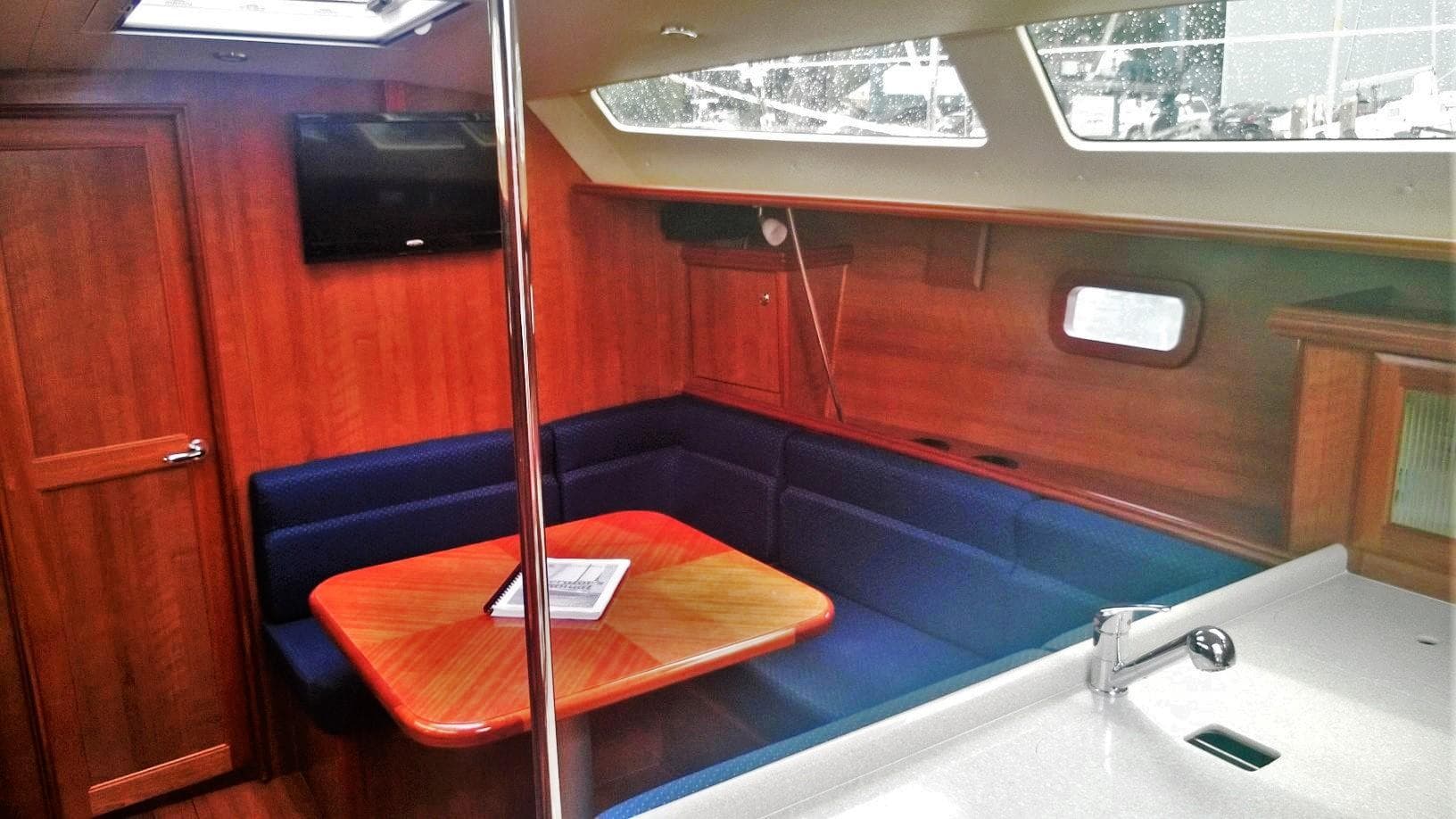 Interior of 2015 Marlow-Hunter 37 sailboat with wood finish and blue seating.