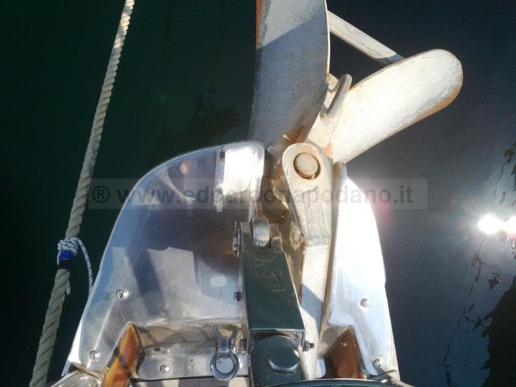 Bow of 1976 Sangermani Ketch with anchor and rope in sunlight.