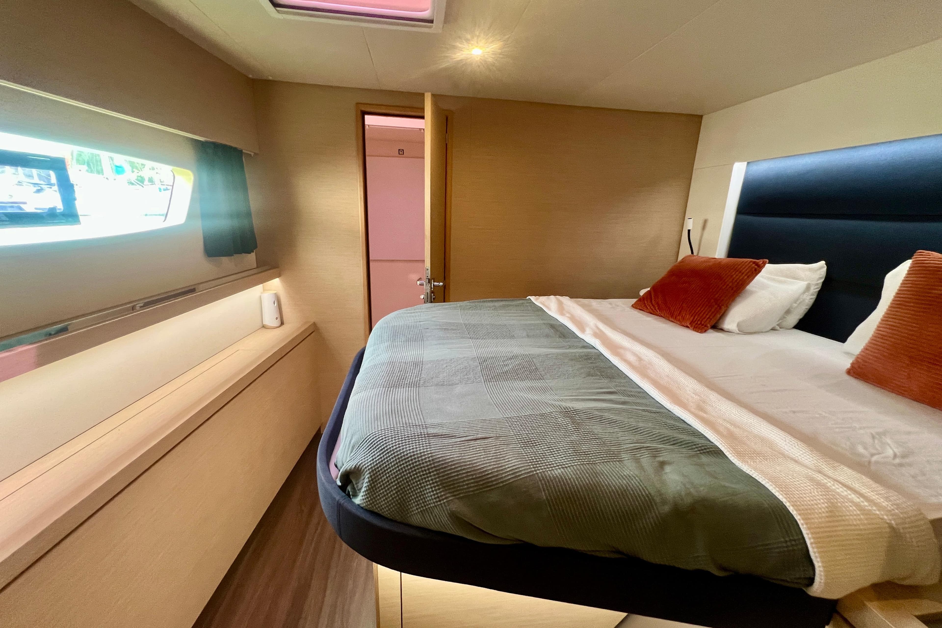 Luxurious cabin interior of 2018 Fountaine Pajot Saona 47 catamaran with cozy bed and window view.
