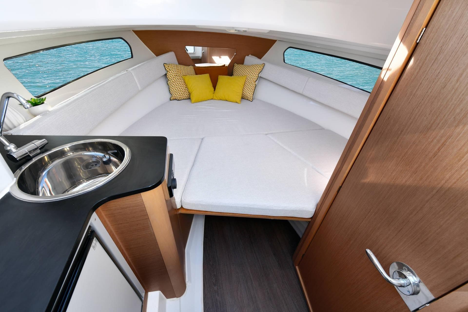 Interior of 2026 Jeanneau Cap Camarat 7.5 WA Serie 3, featuring cozy cabin and kitchenette.