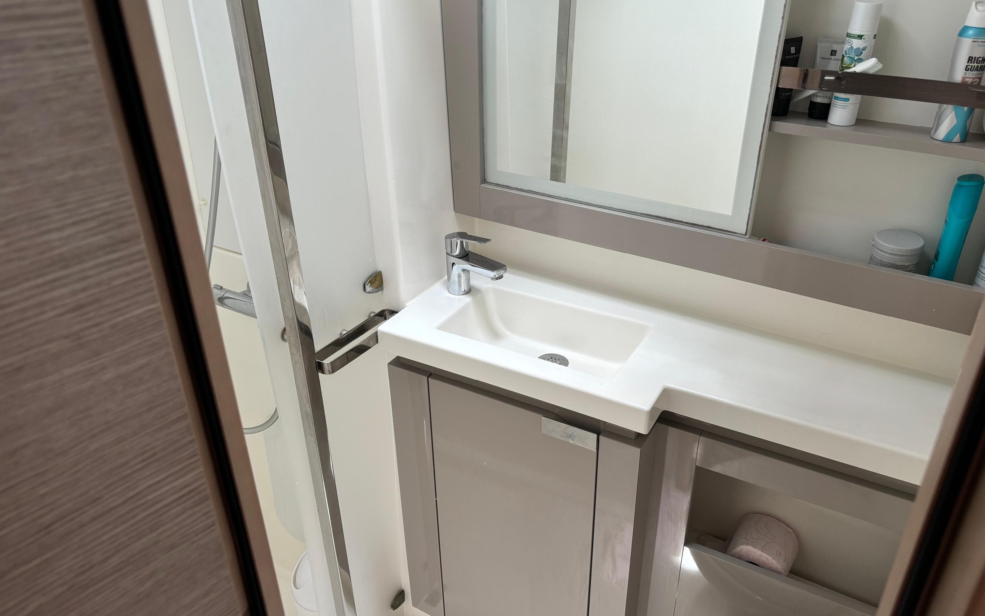 Modern bathroom in 2021 Fountaine Pajot Catamaran Elba 45, featuring sleek sink and storage.