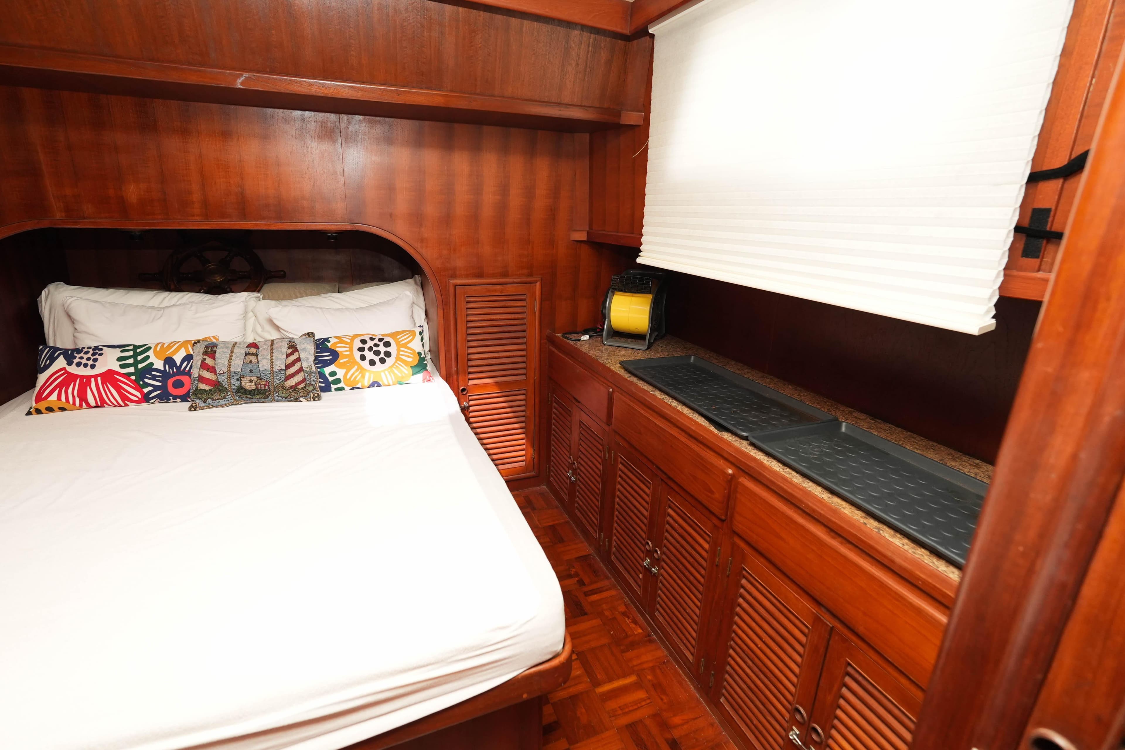 Cozy cabin interior of 1982 CHB Classic Trawler 41 with wooden furnishings and colorful pillows.
