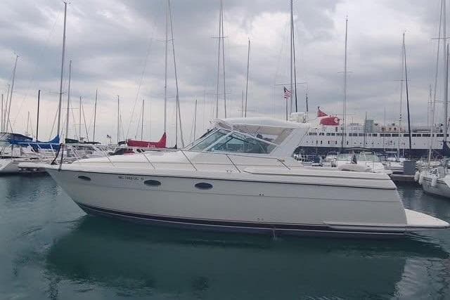 1995 Tiara Yachts 3500 Express docked in a marina under cloudy skies.