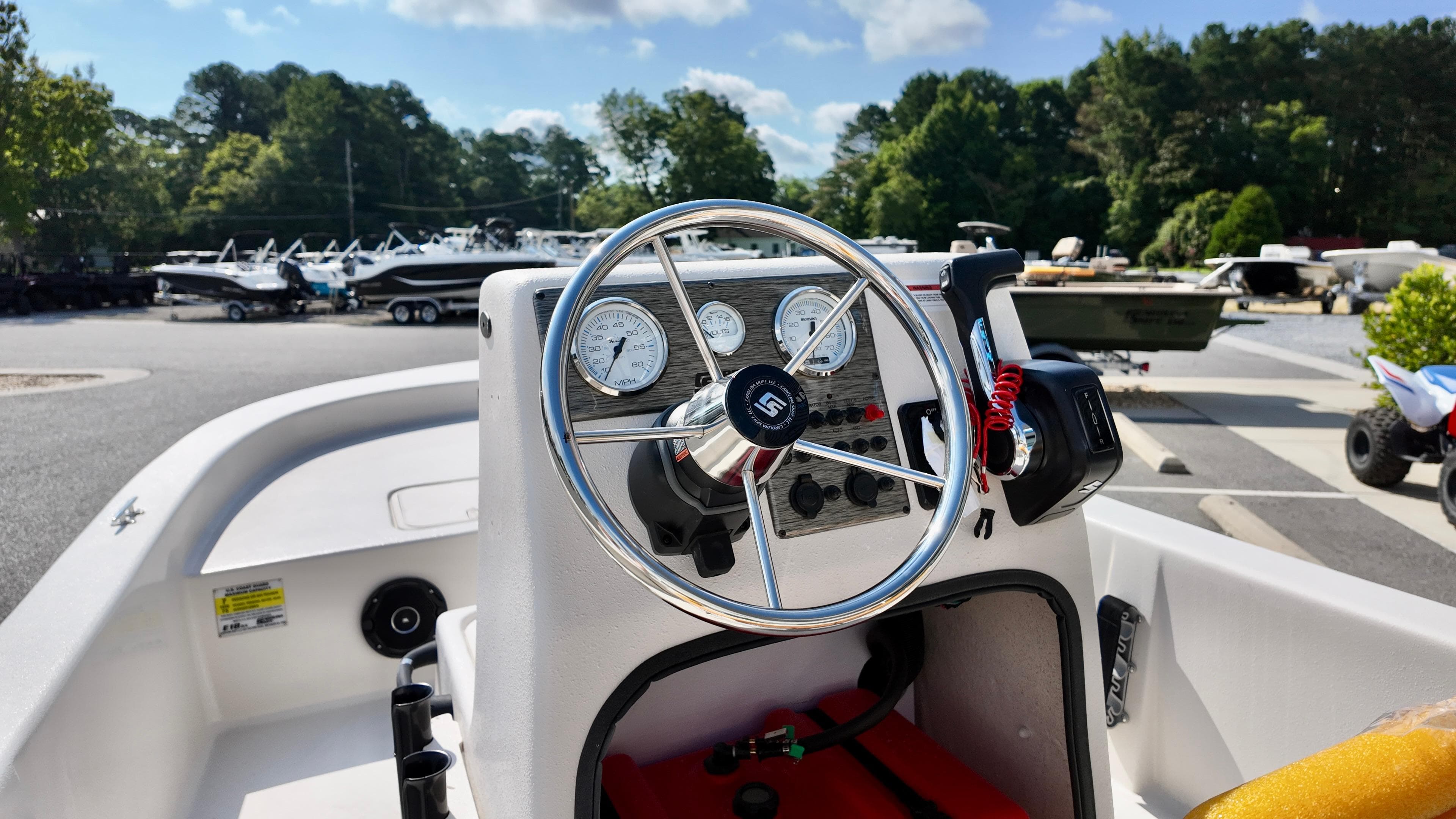 2025 Carolina Skiff E18 JVX CC boat dashboard with steering wheel and controls.