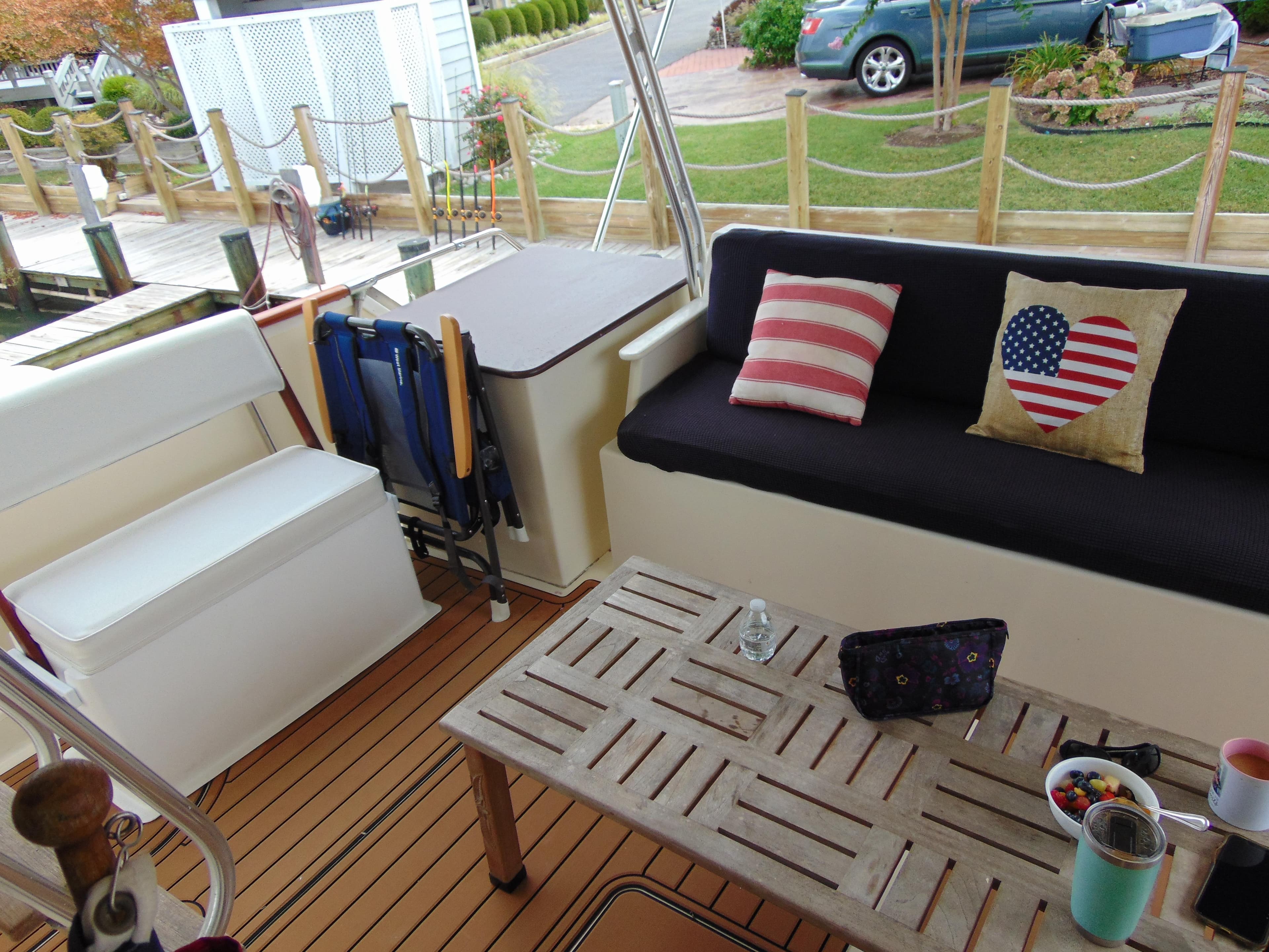 1972 Hatteras Yachtfish deck with seating, table, and patriotic pillows.