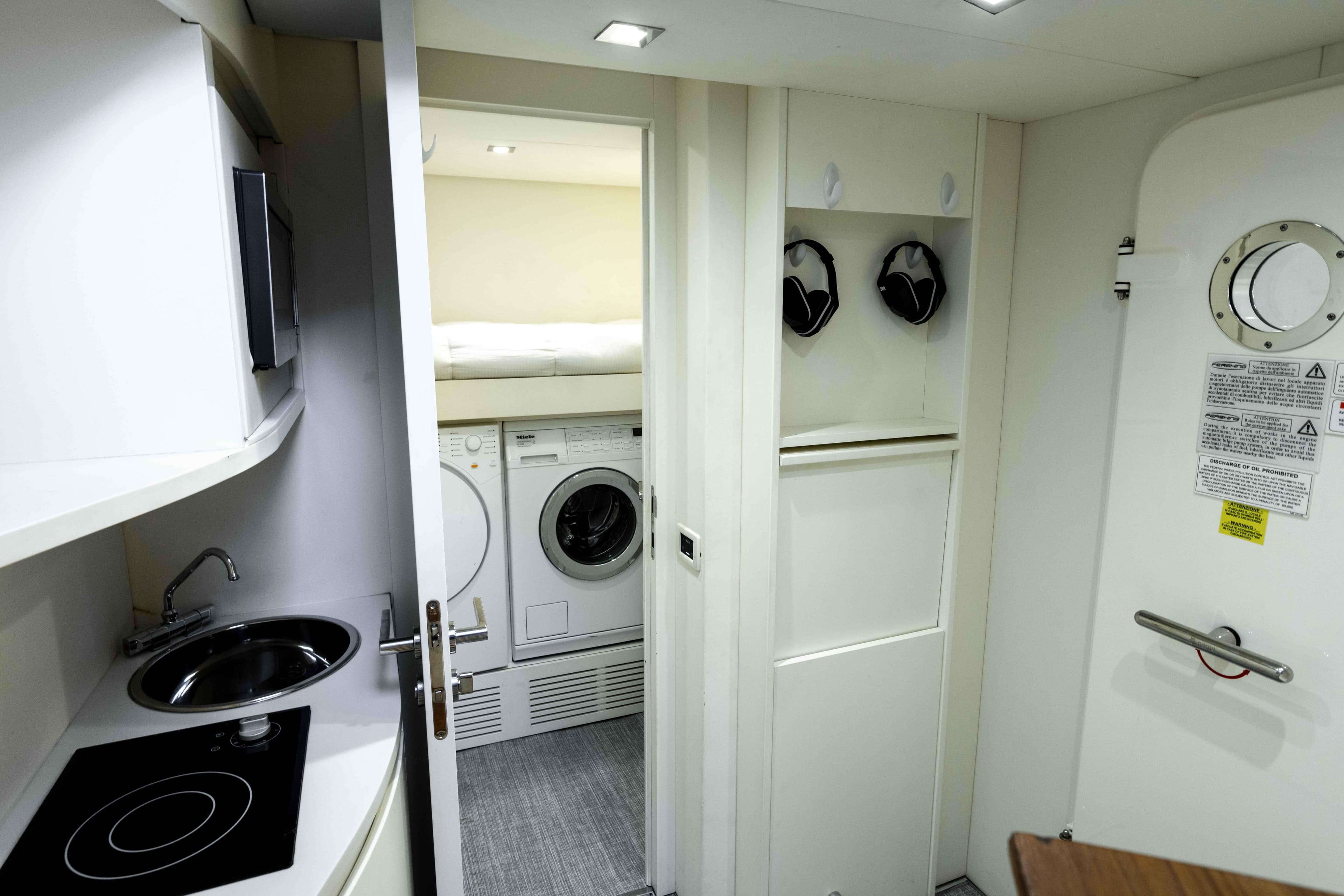 Compact interior of 2017 Pershing 74 yacht with kitchenette and laundry area.