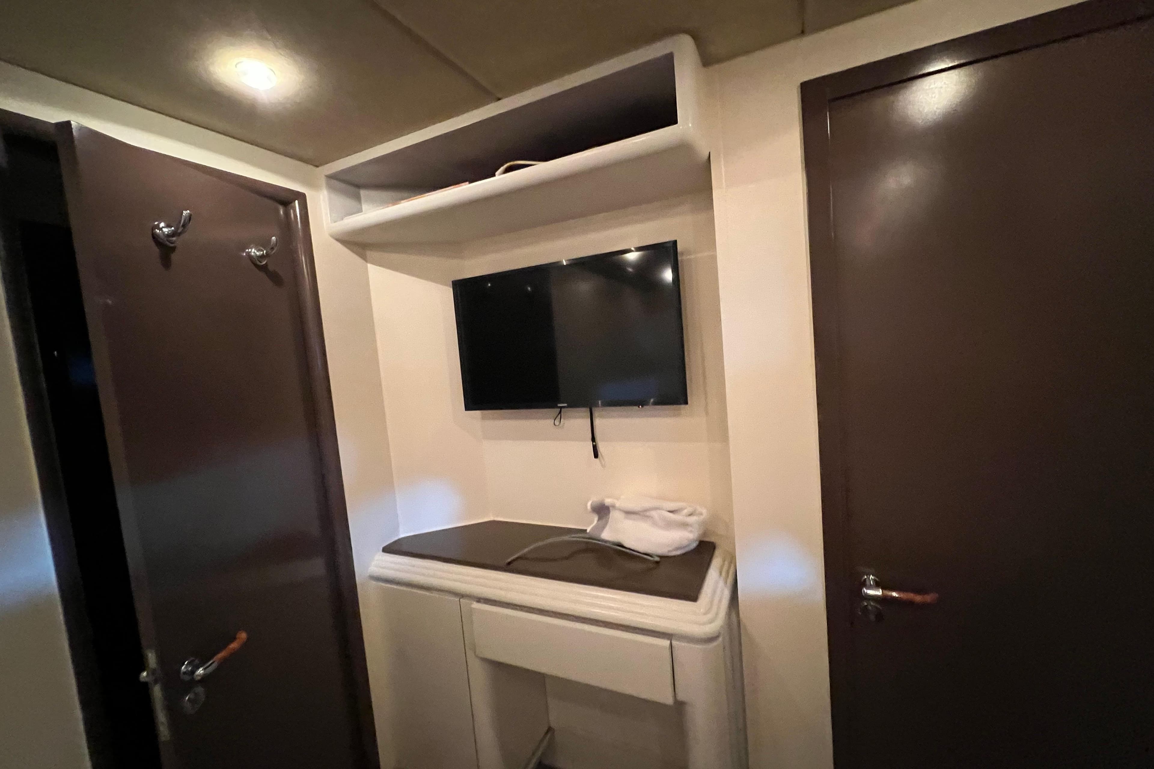 Interior of Falcon 106 yacht, featuring a wall-mounted TV and storage area, 2001 model.