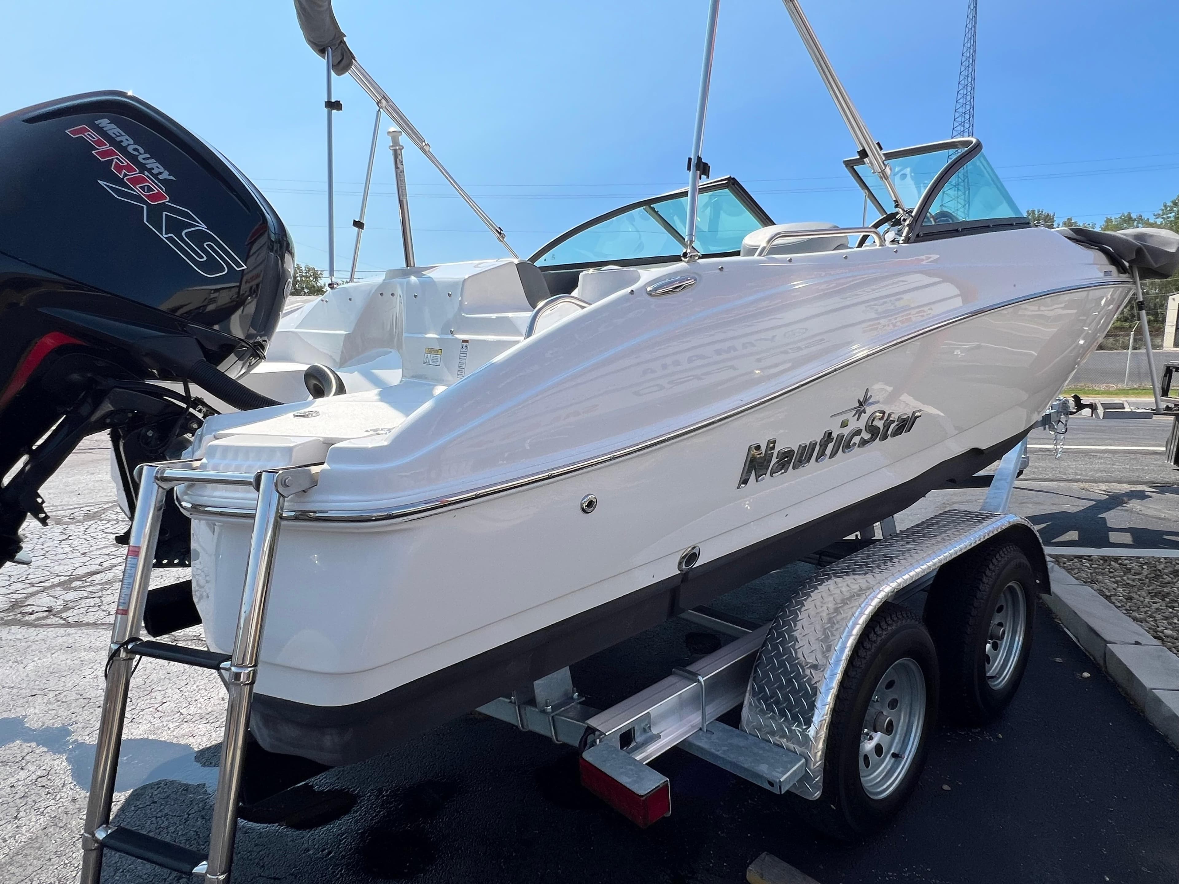 2023 NauticStar 203 DC boat on trailer, featuring sleek design and powerful engine.