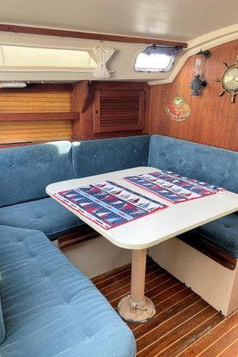 Interior of 1988 Catalina 30 MkII sailboat with blue seating and wooden accents.