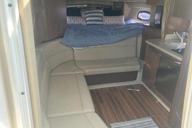 Interior of 2010 Chaparral Signature 310 boat with seating, bed, and kitchenette.
