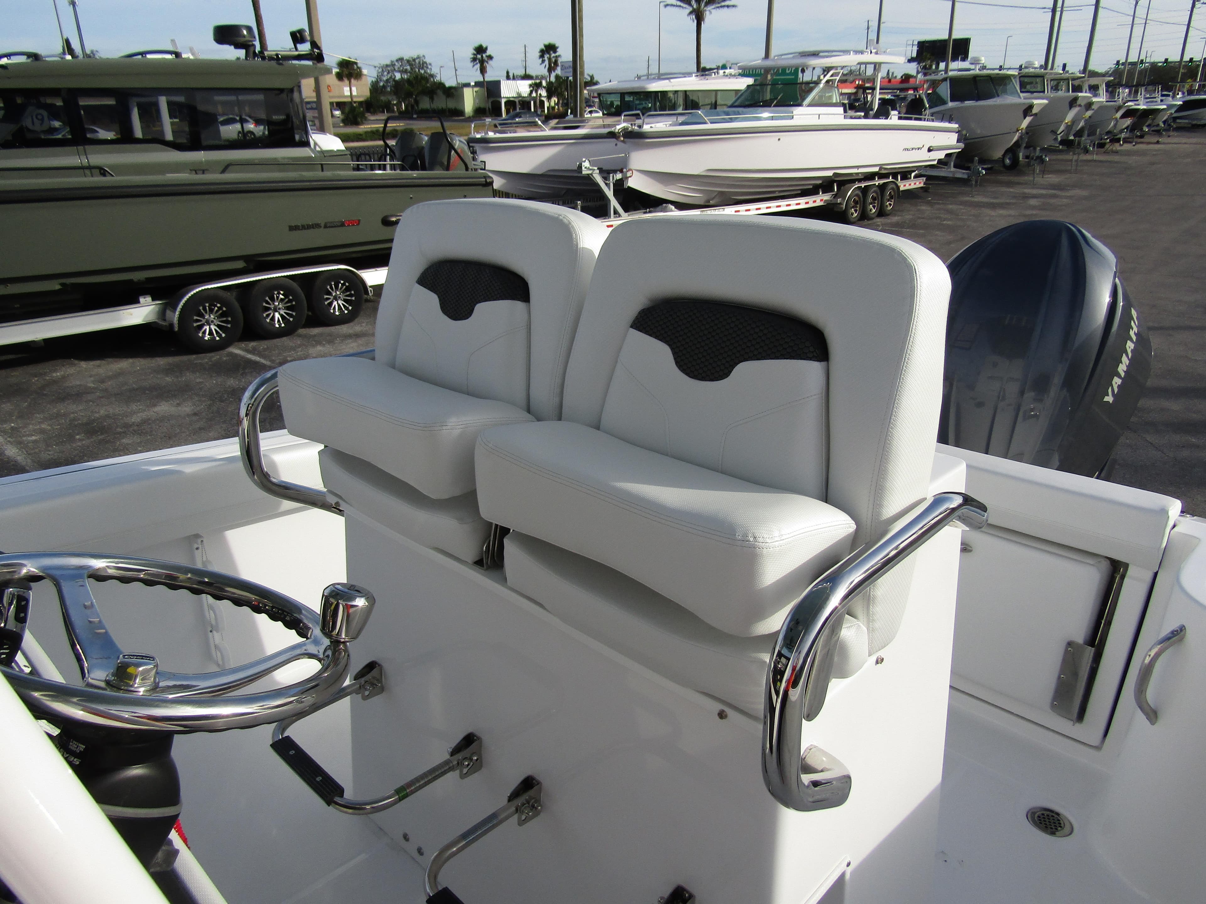 2025 Wellcraft 243 Fisherman boat interior with dual white seats and steering wheel.