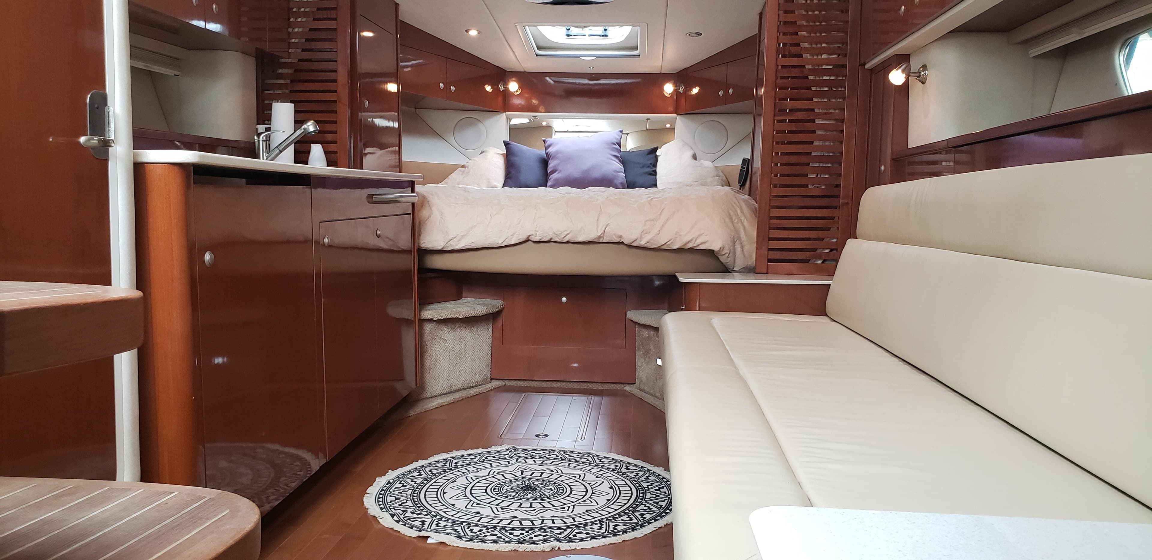 Interior of 2009 Sea Ray 350 Sundancer with bed and sofa.
