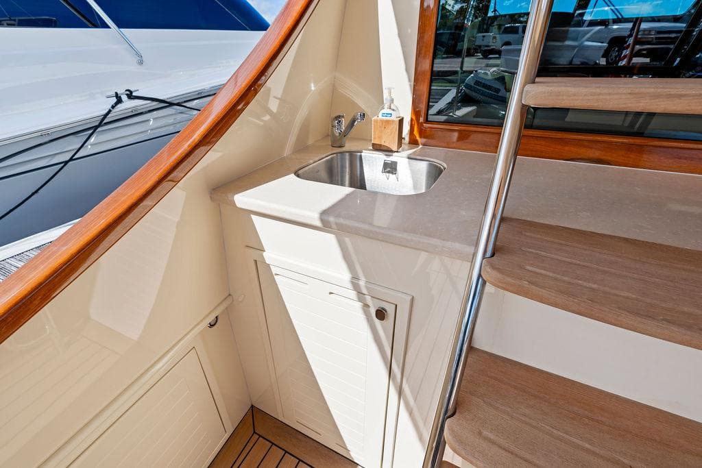 2018 Palm Beach Motor Yachts PB55 Flybridge with sink and wooden stairs detail.