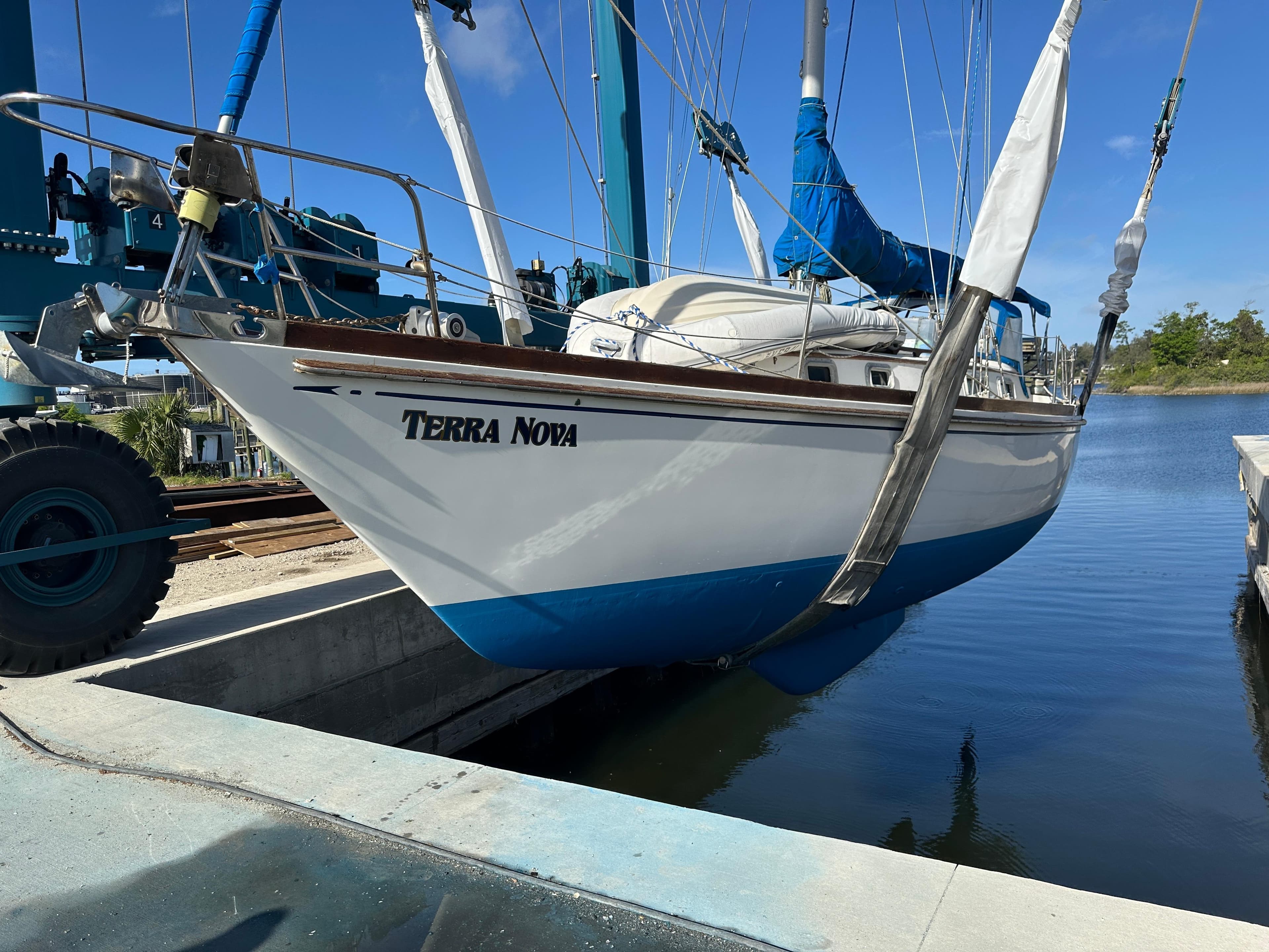 1984 Bristol 38.8 sailboat "Terra Nova" in dry dock, blue hull, clear sky background.