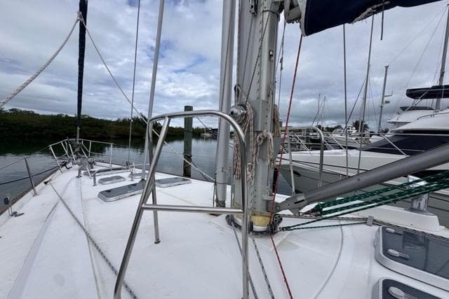 Sailboat deck view of a 1996 Beneteau 50 in a marina setting.