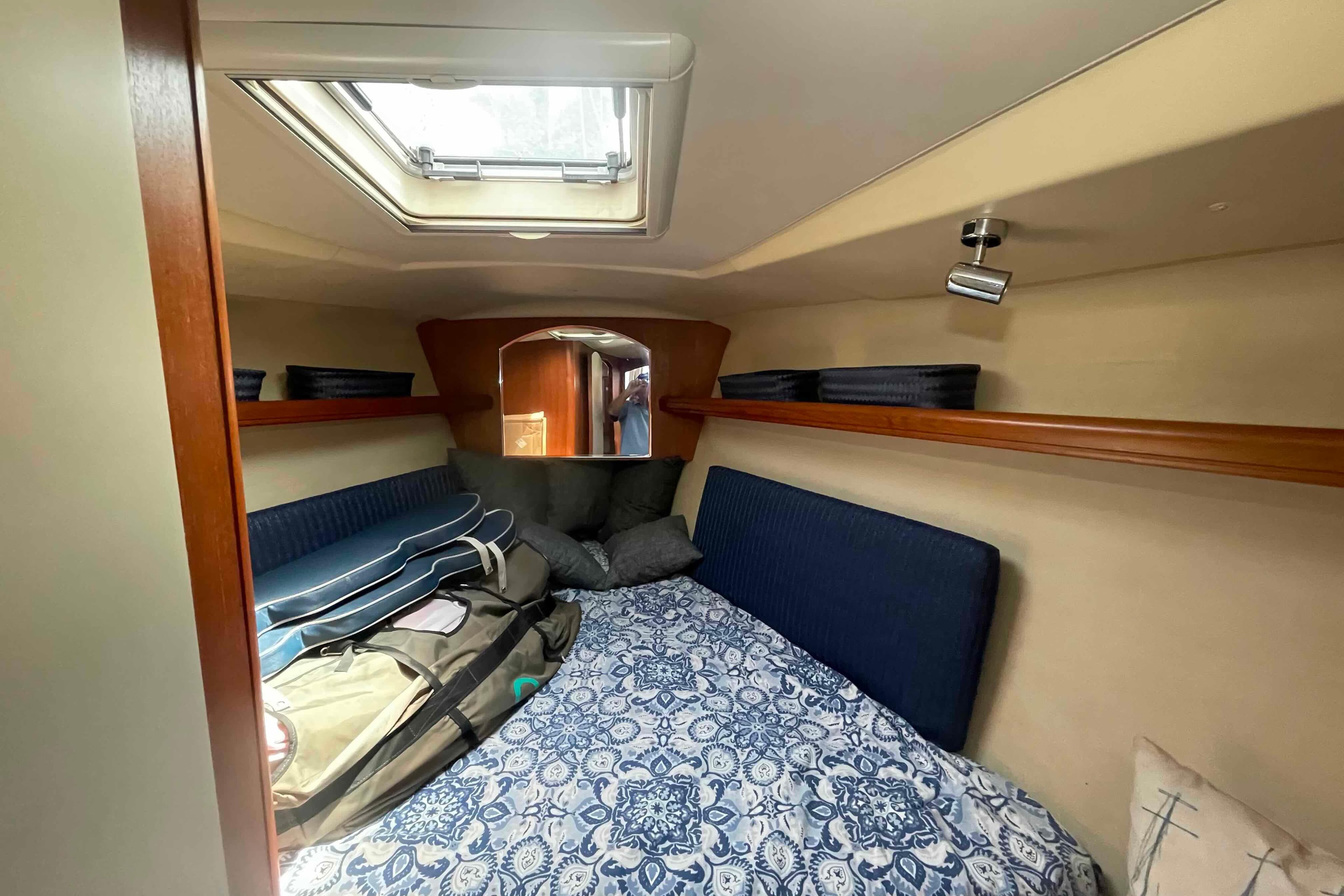 Cozy cabin interior of 2003 Hunter 426 Deck Salon sailboat with skylight and patterned bedding.