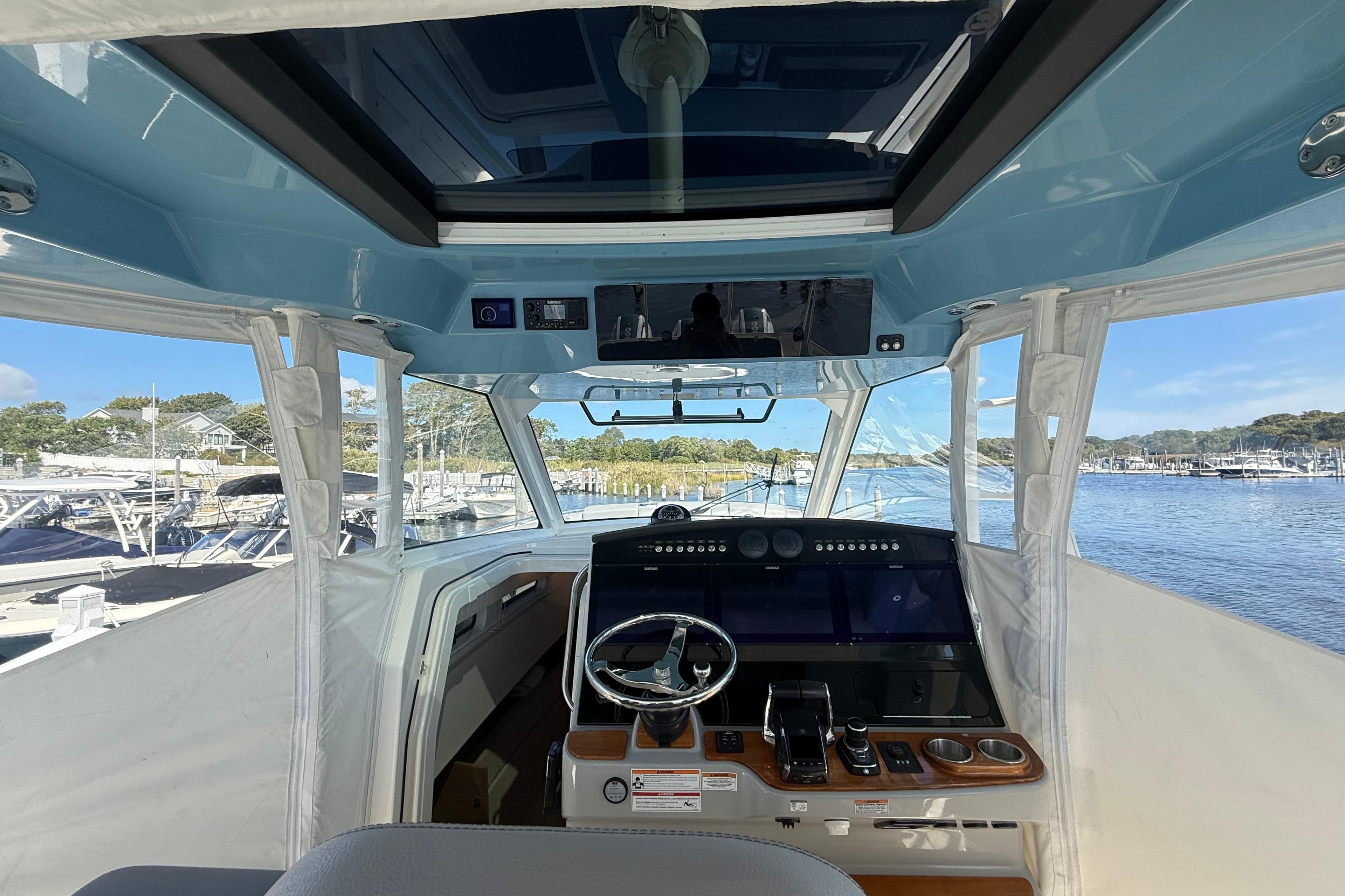 2024 Boston Whaler 420 Outrage helm with advanced navigation system and panoramic marina view.