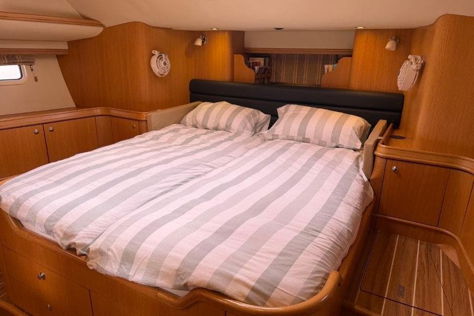 Luxurious cabin interior of 2011 Discovery 55 yacht with striped bedding.