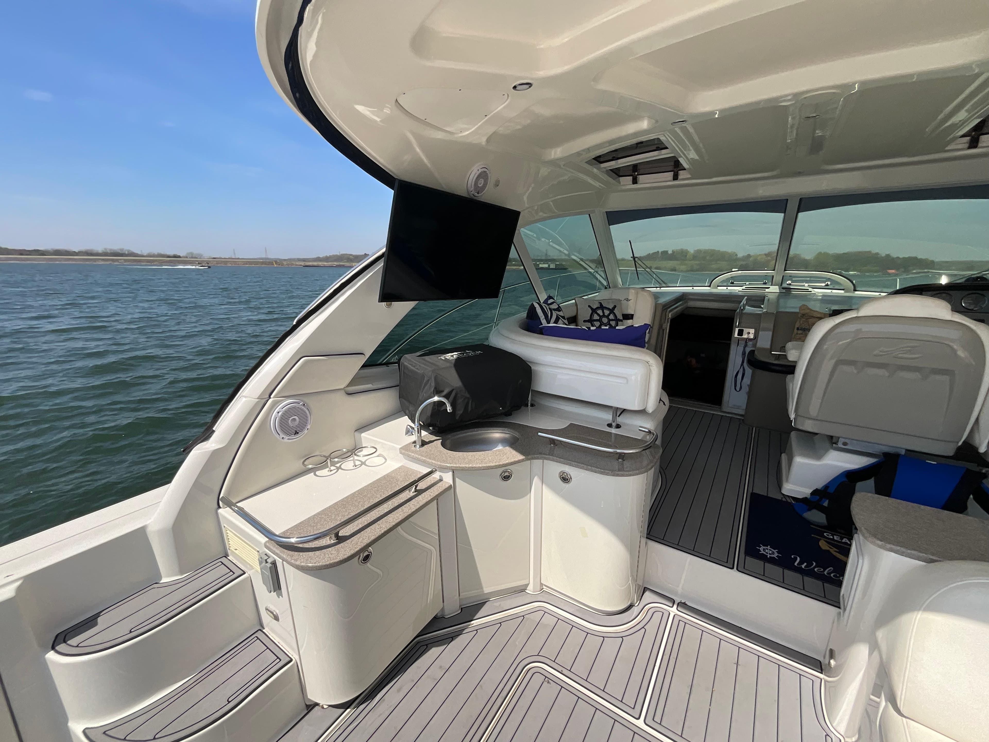 2006 Sea Ray 48 Sundancer yacht interior with seating, TV, and water view.