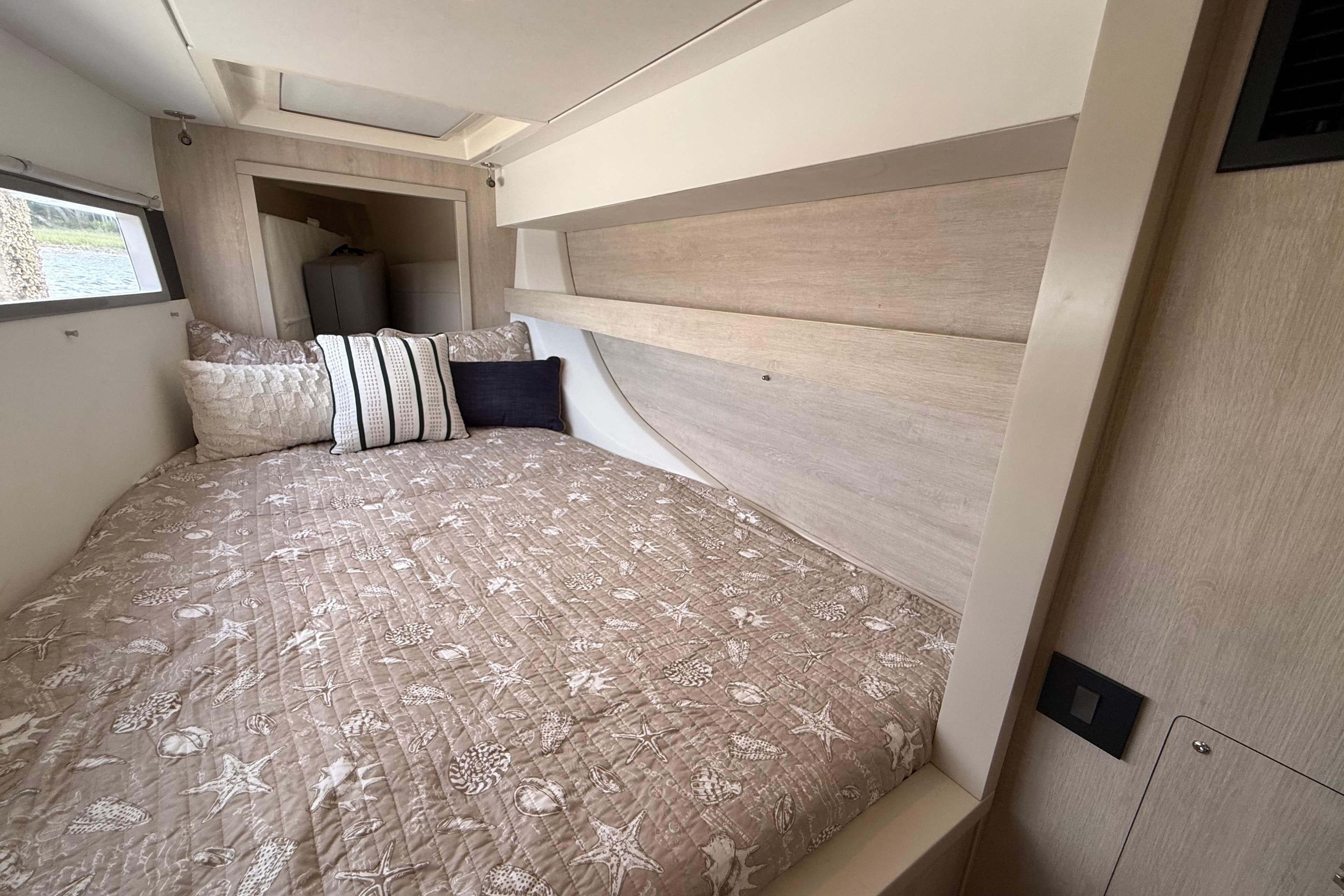 Cozy bedroom interior of 2021 Leopard 43 Powercat with nautical-themed bedding.