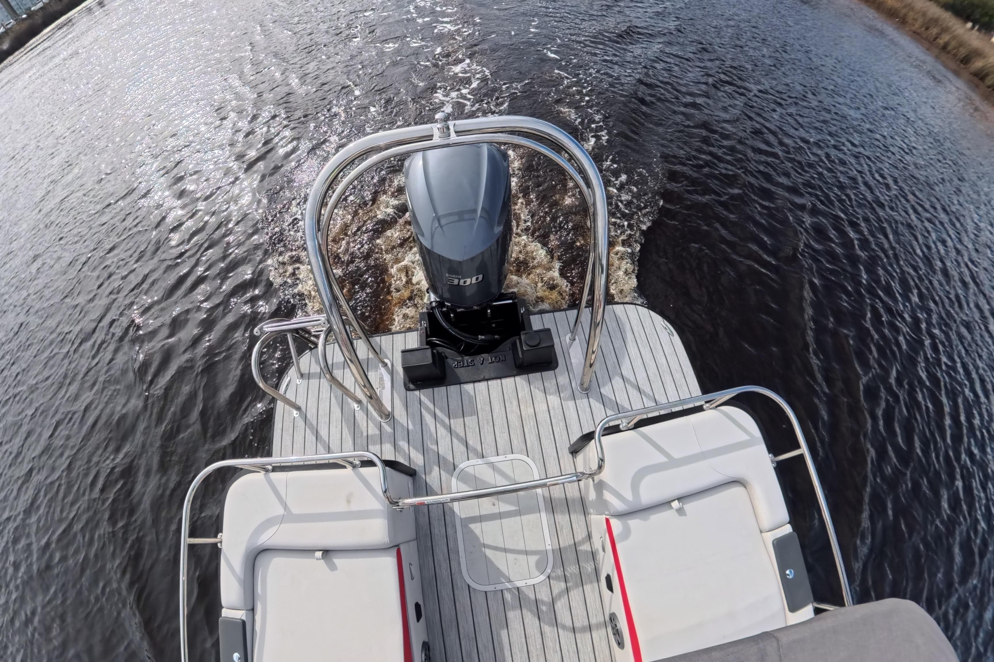 2025 SunCatcher ELITE SERIES 324 SS boat with powerful outboard motor on water.