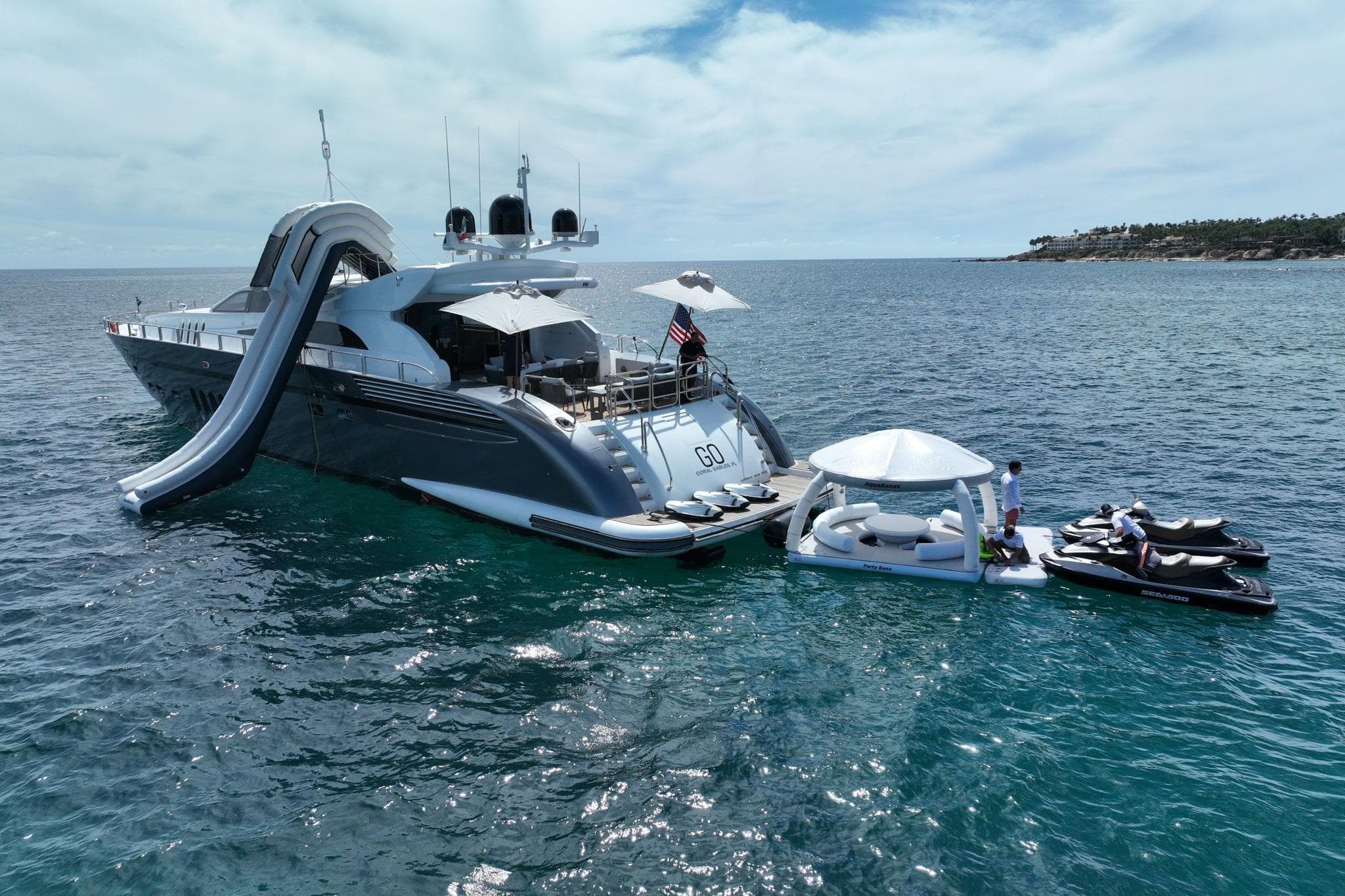 Luxurious 2008 Arno Leopard 34 yacht with slide, jet skis, and floating lounge in serene ocean.