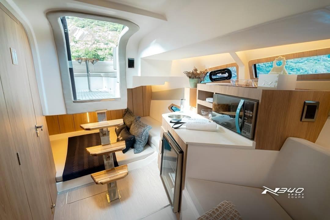 Interior of 2026 NX Boats NX340, featuring modern kitchen and cozy seating area.