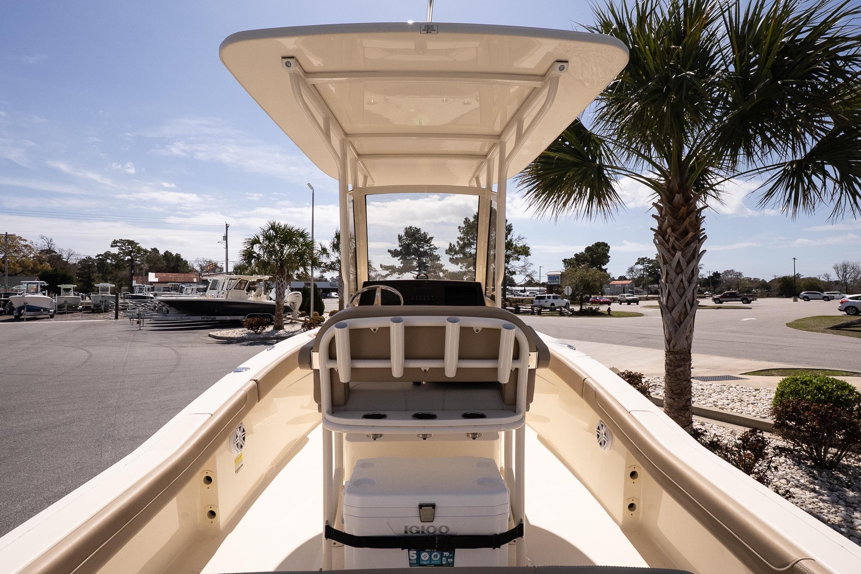 2026 Scout 215 XSF boat with T-top, parked near palm trees in a sunny marina.