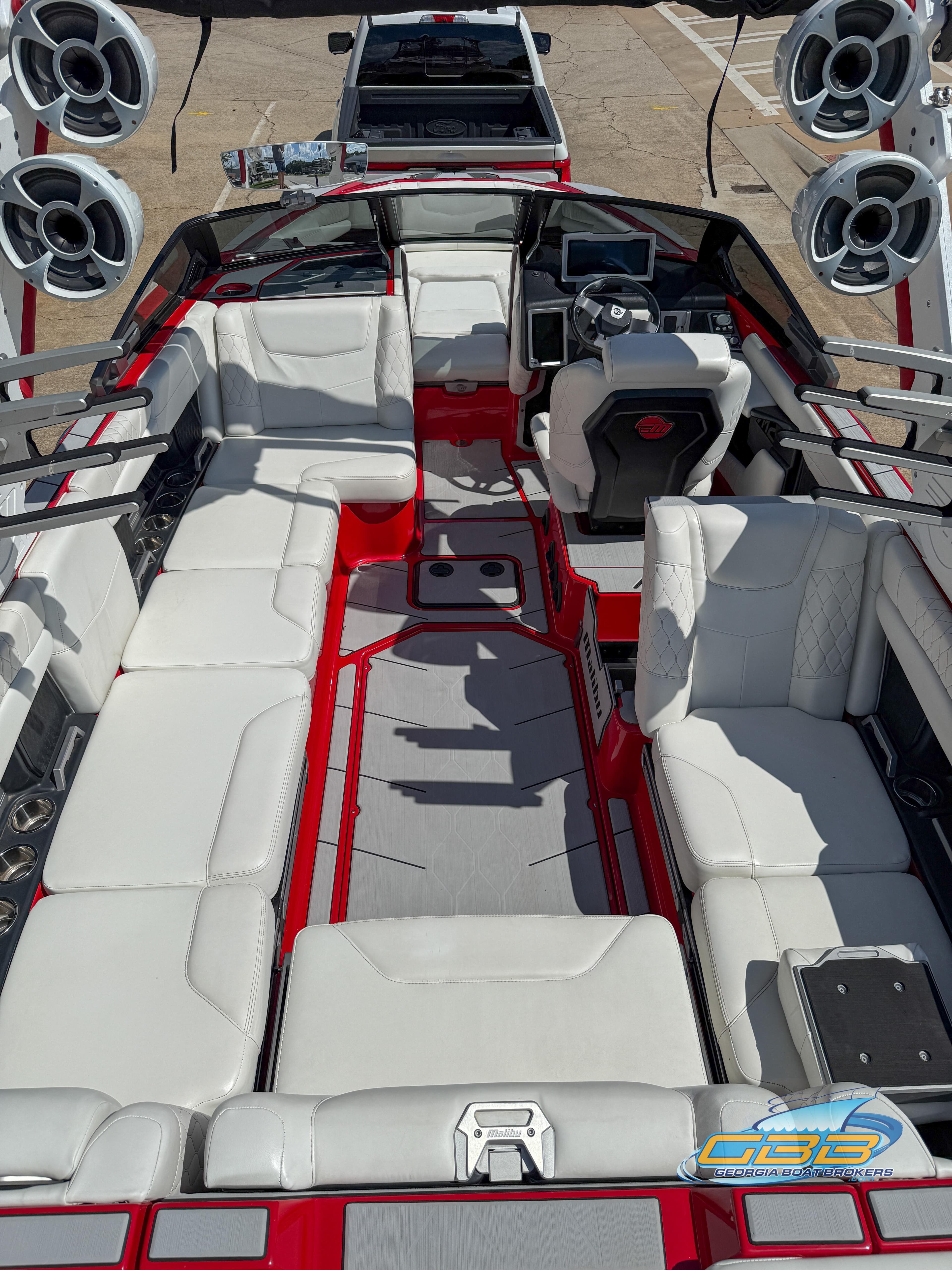 2021 Malibu M240 boat interior with white seating, red accents, and multiple speakers.