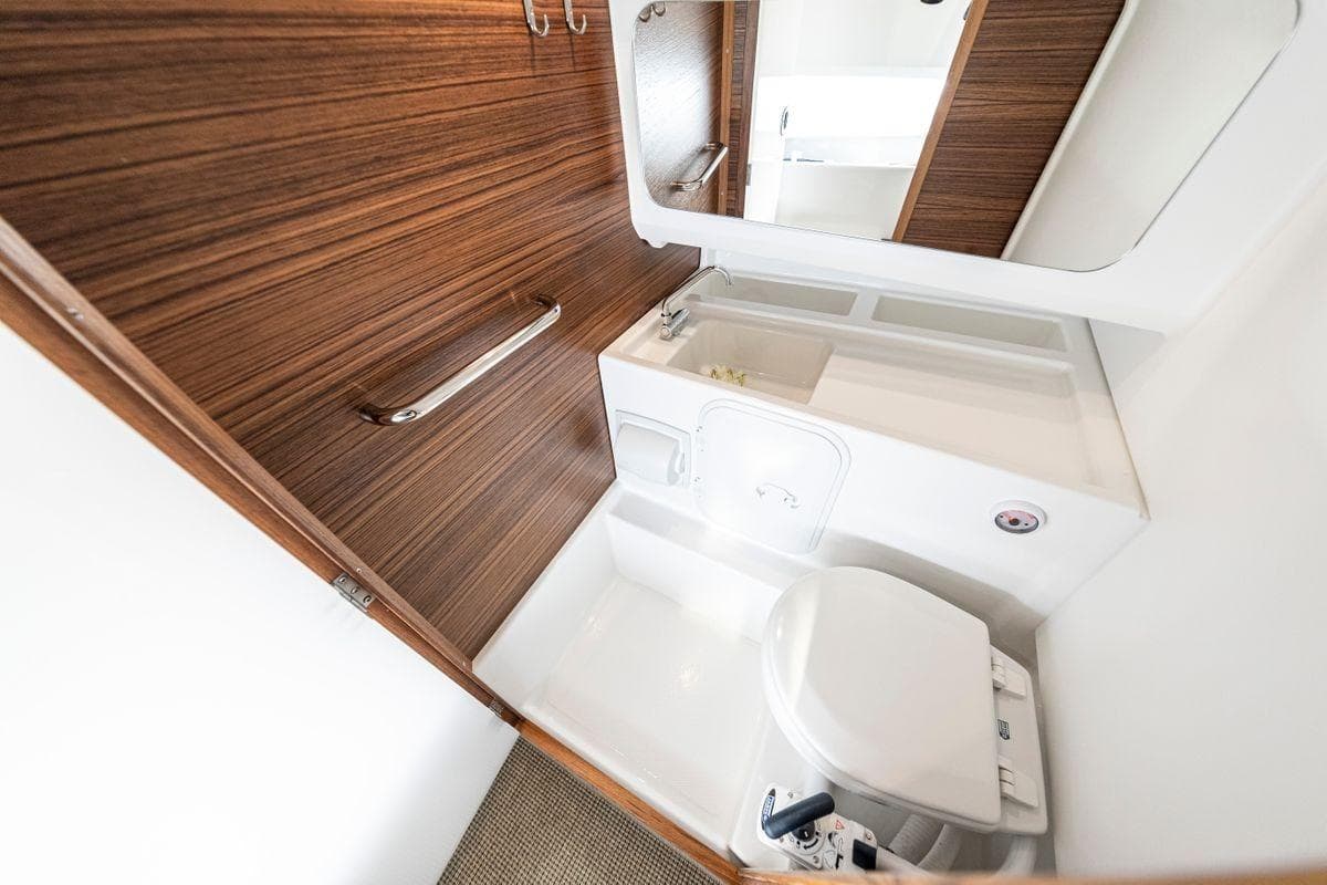 Modern bathroom in 2025 Nimbus Tender 8 boat with wood accents and compact design.