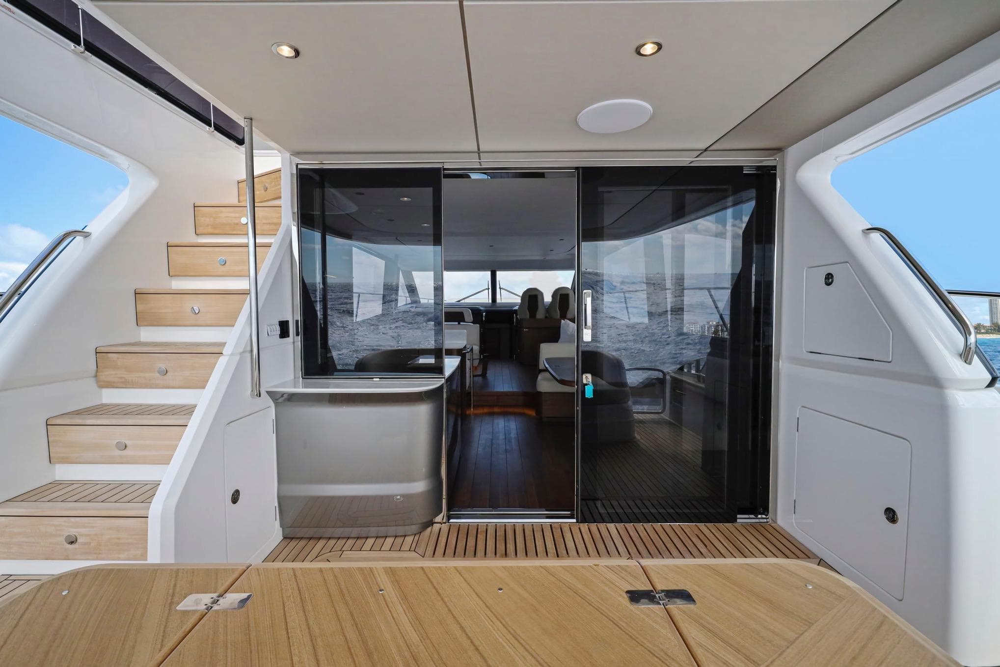 Luxurious 2026 Princess F65 yacht interior with wooden stairs and glass doors.