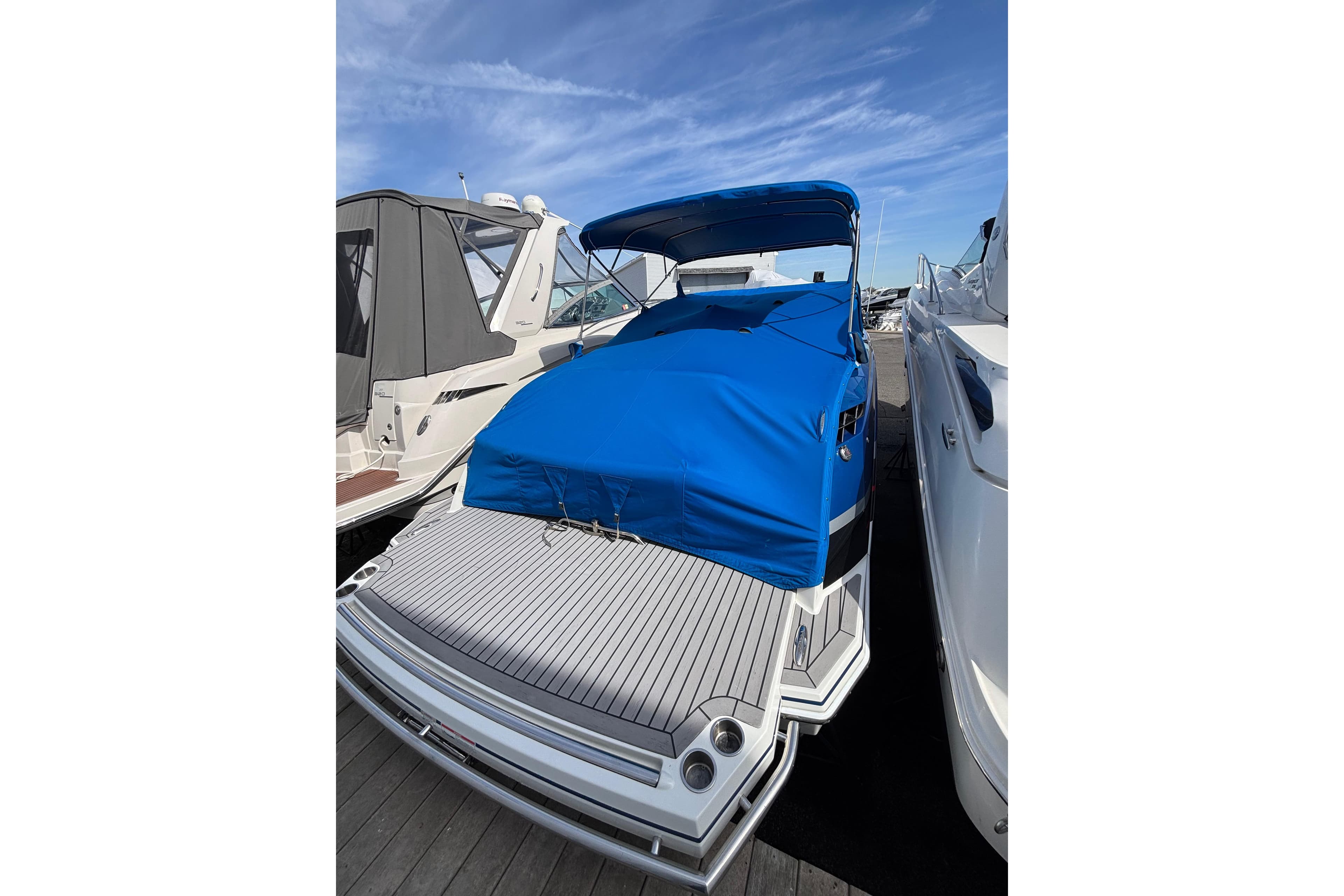 2018 Formula 330 Crossover Bowrider I/O with blue cover docked at marina.