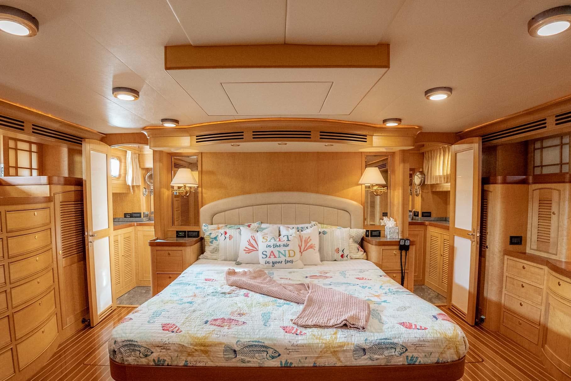 Luxurious bedroom interior of 2006 Marlow 72E LRC yacht with elegant wood finishes.