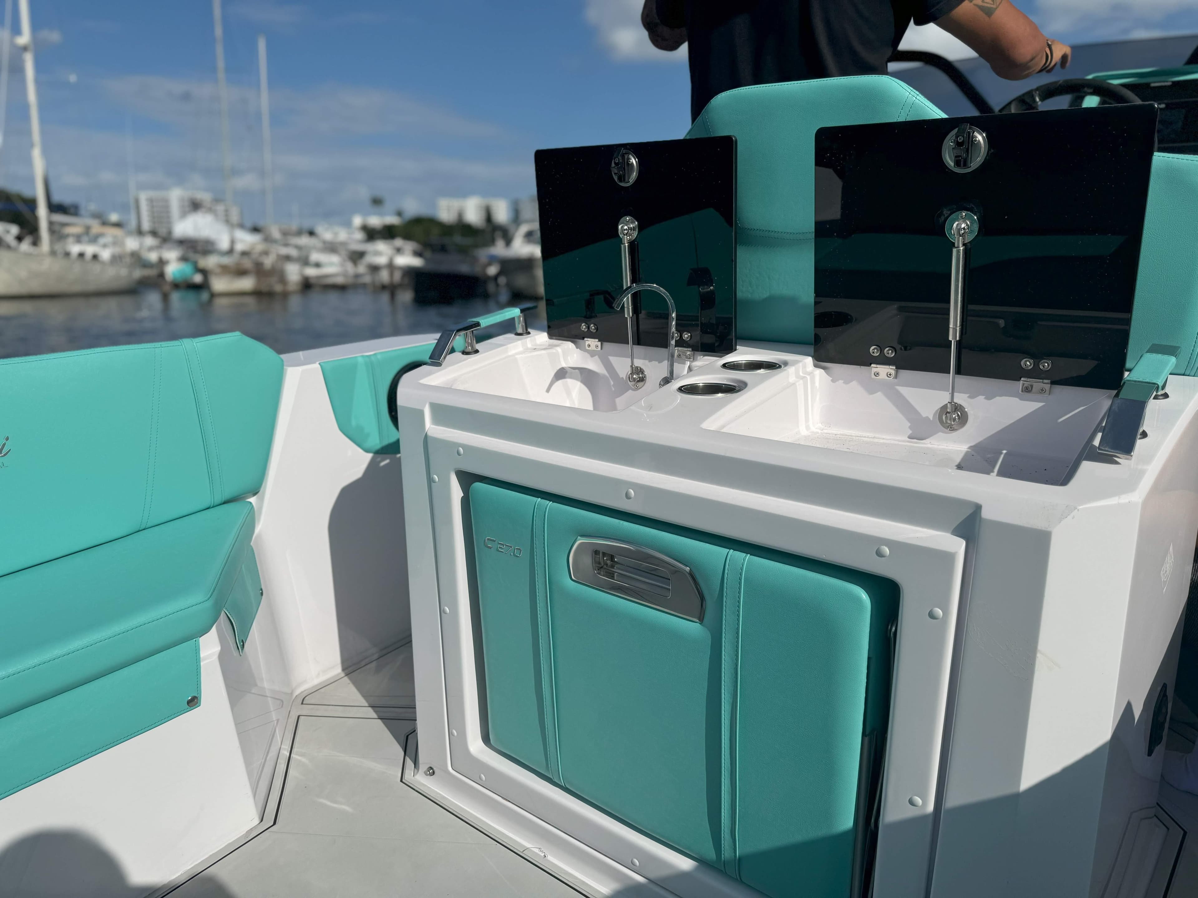 2025 Ranieri CAYMAN 27.0 SPORT TOURING boat interior with teal seating and sink area.
