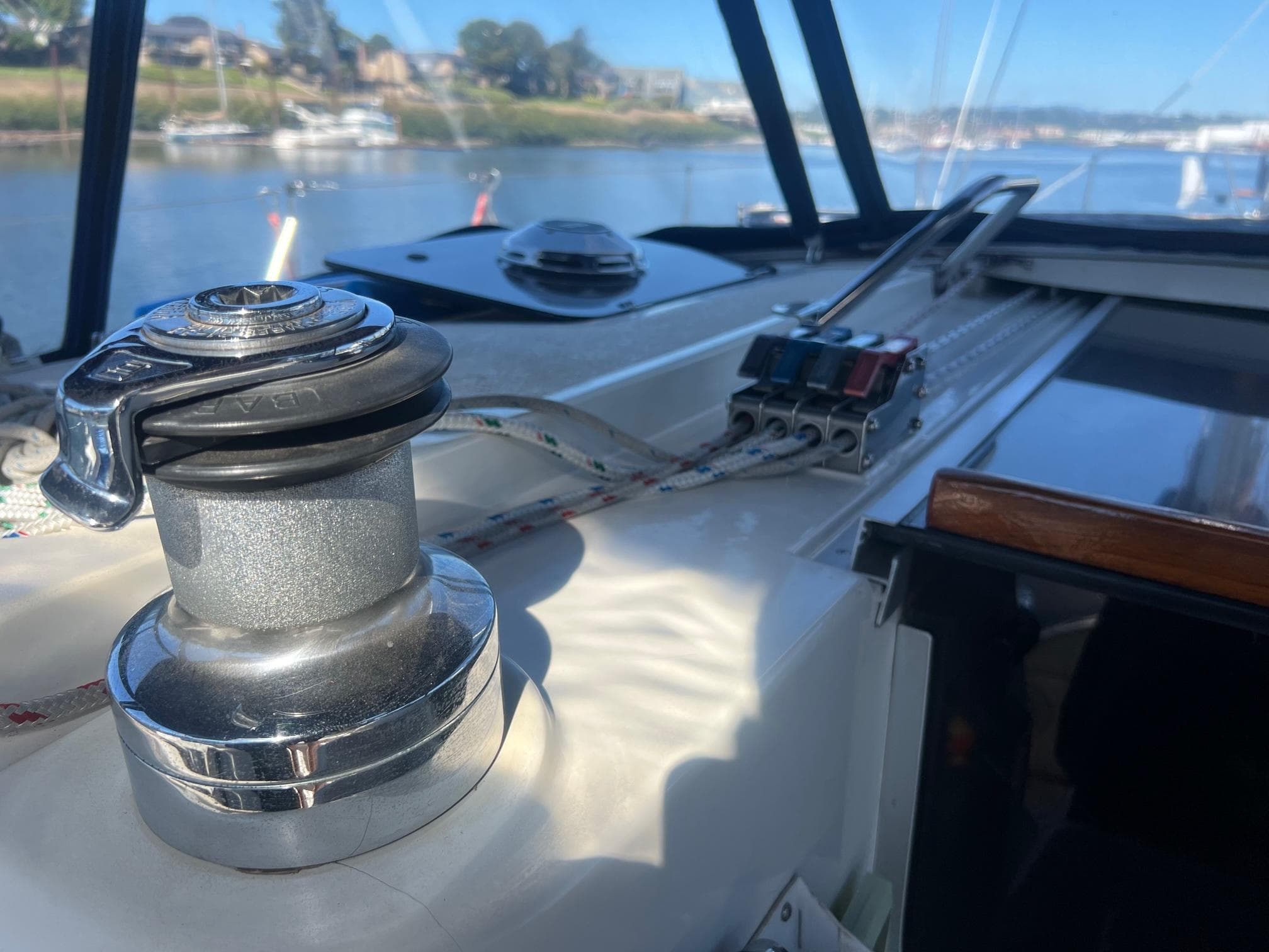 Sailboat deck of 1992 Hunter 43 with winch and control panel, overlooking marina.