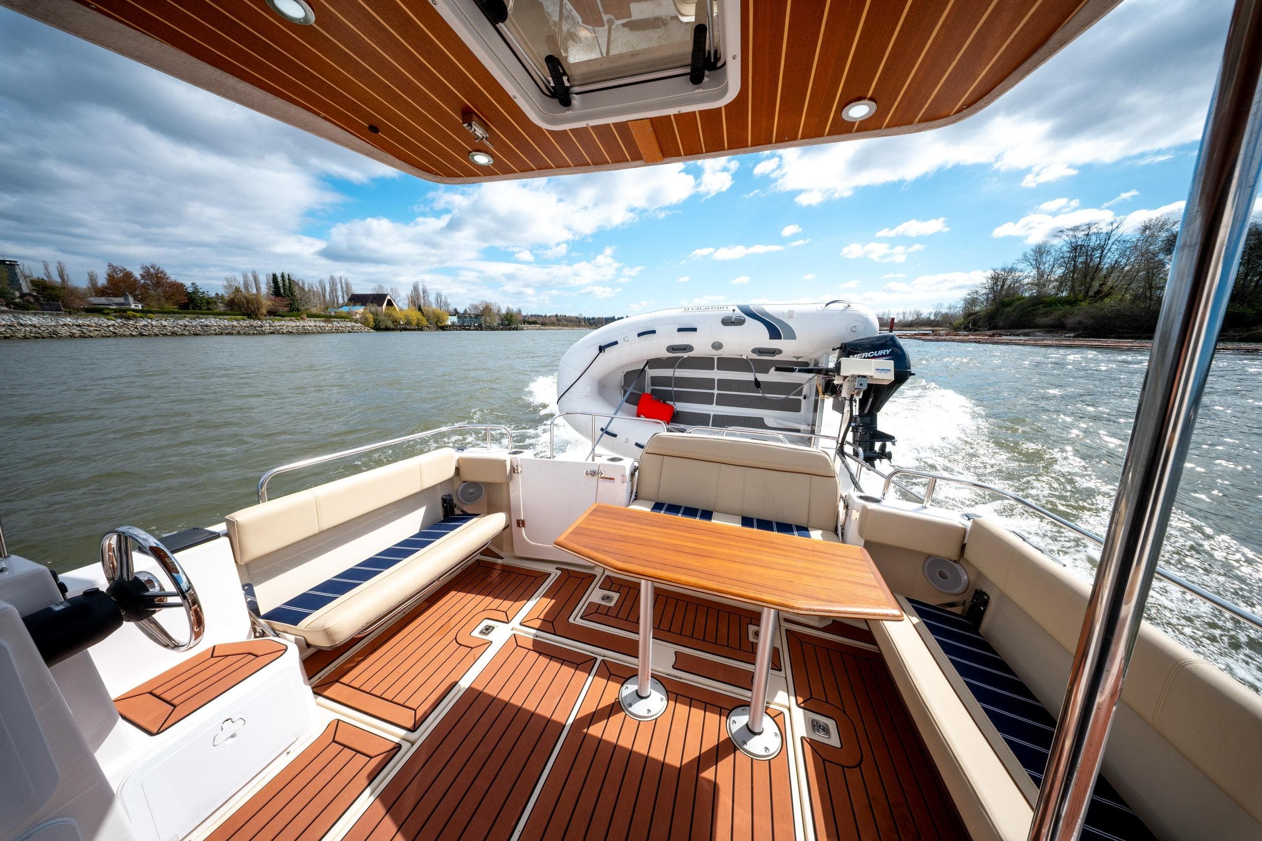 2023 Ranger Tugs R-29 CB boat interior with wooden deck and seating on a sunny day.