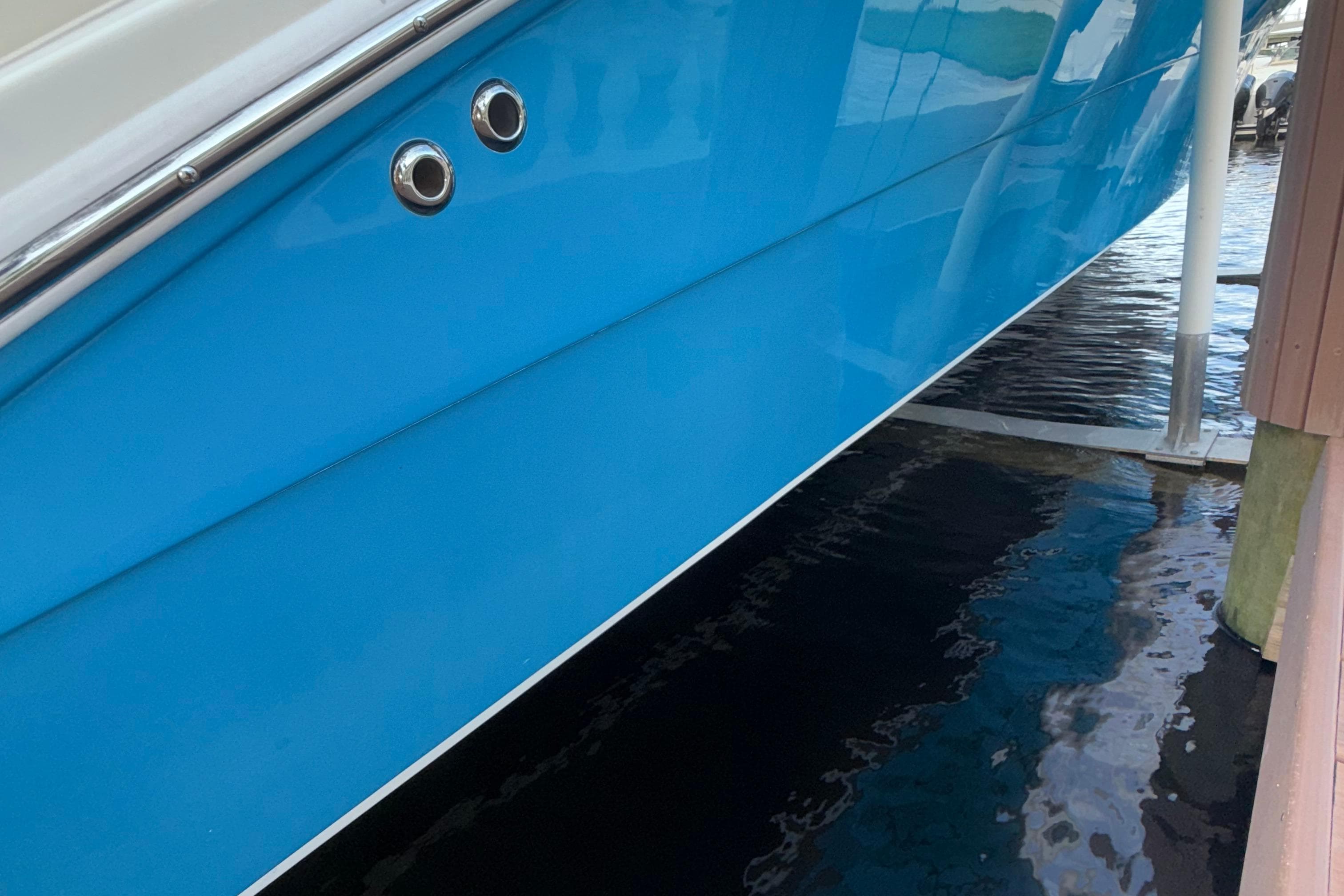 Blue hull of 2021 Marlin 39 CC boat docked above water.