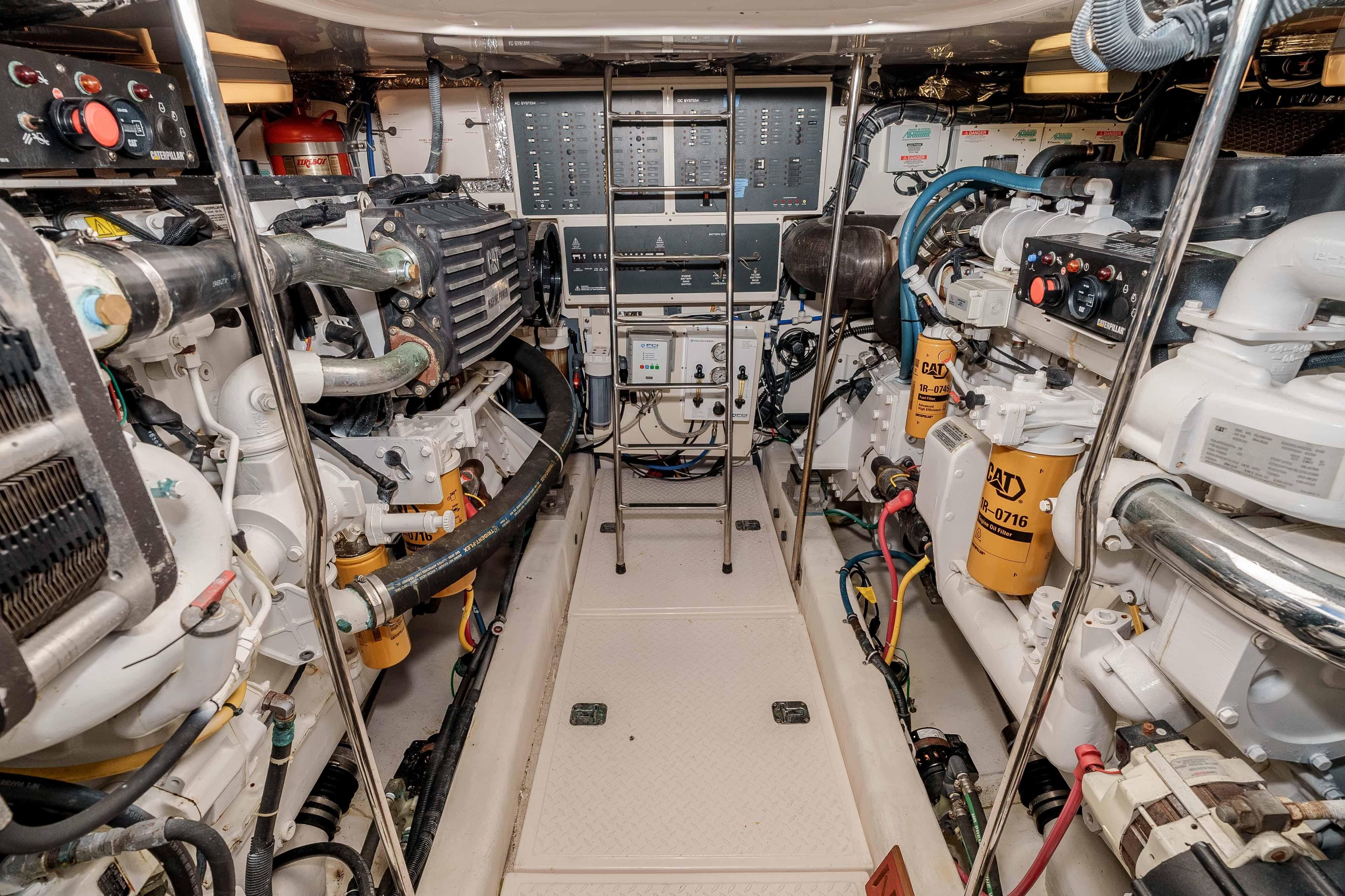 Engine room of 2006 Tiara Yachts 5200 Sovran Salon, featuring dual engines and control panels.