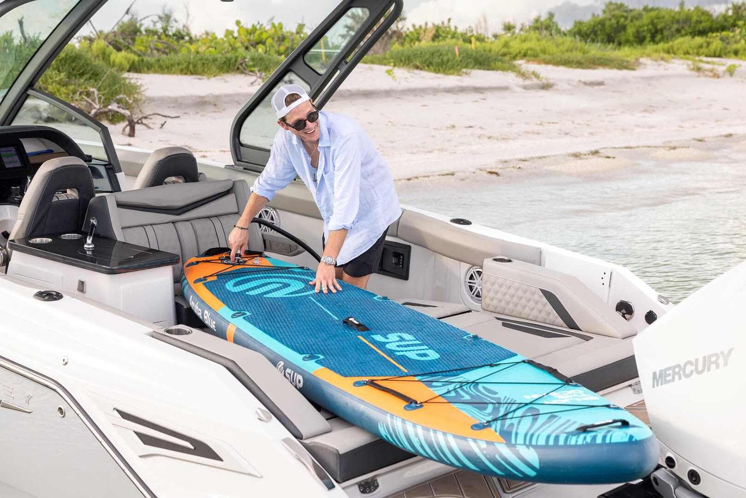 Manufacturer Provided Image: Man loading paddleboard onto 2026 Monterey Elite 30 OB boat at beach.