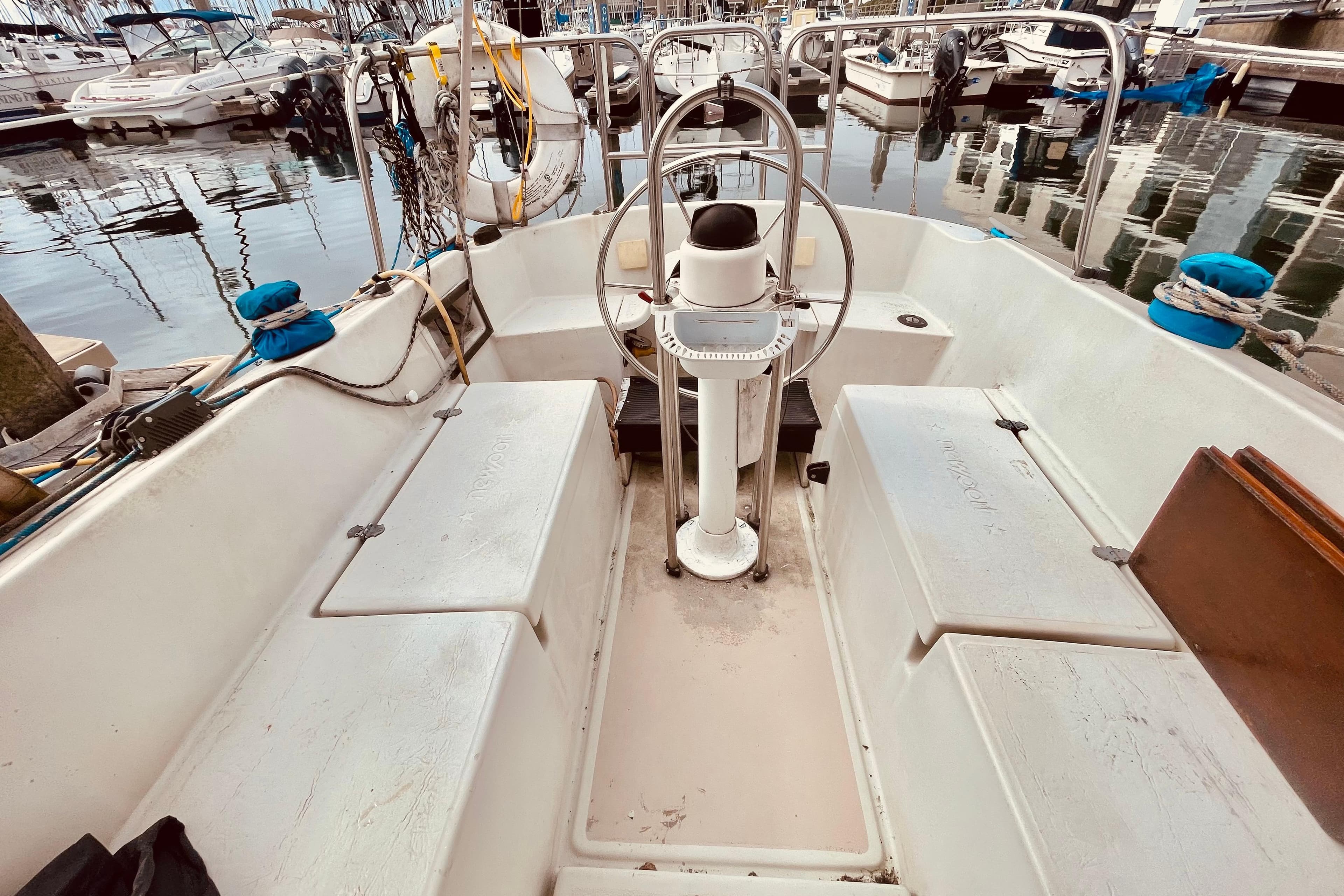 Cockpit of a 1982 Newport 28 sailboat docked at a marina.