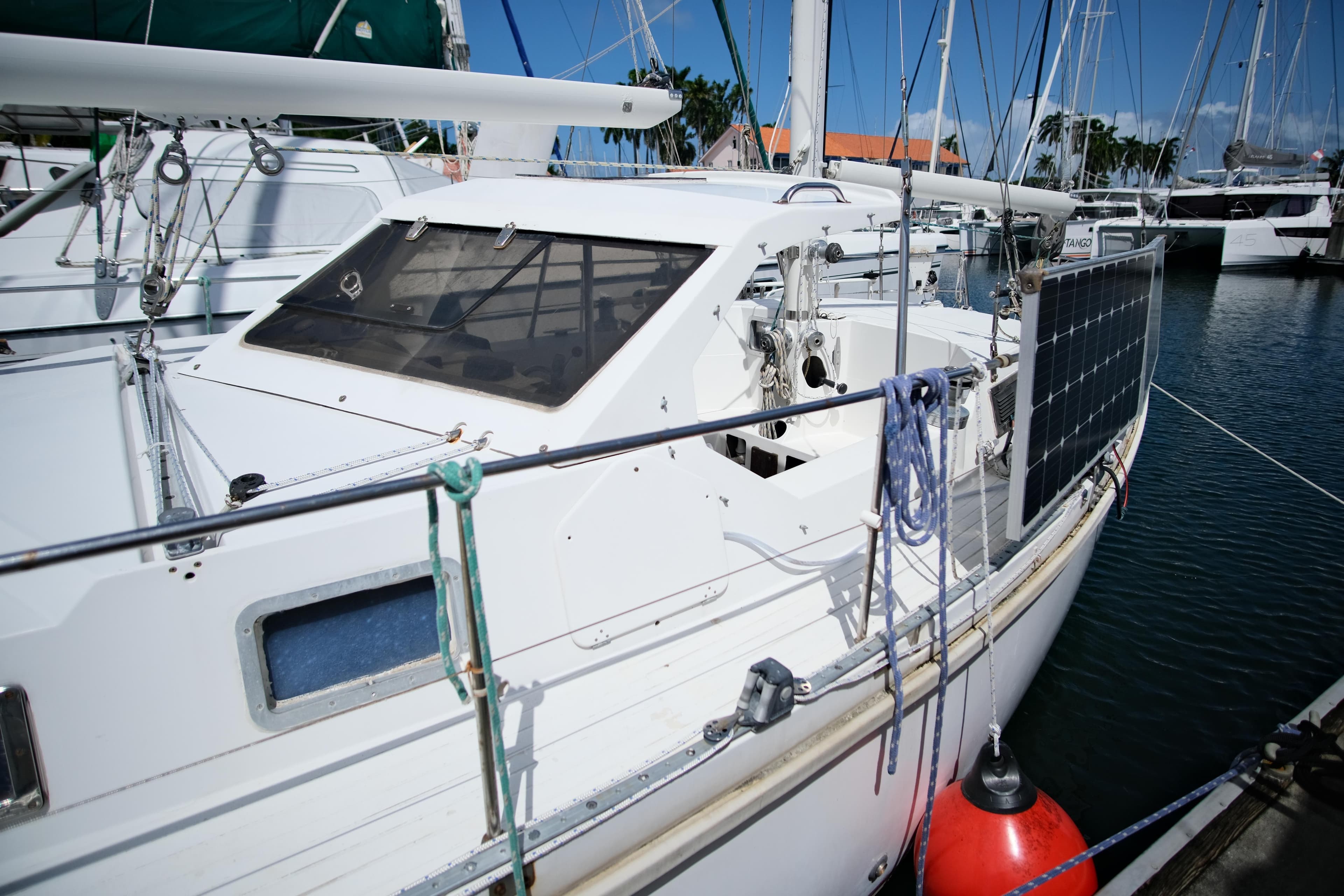 1985 Amel Sharki sailboat docked, featuring solar panel and sleek design.
