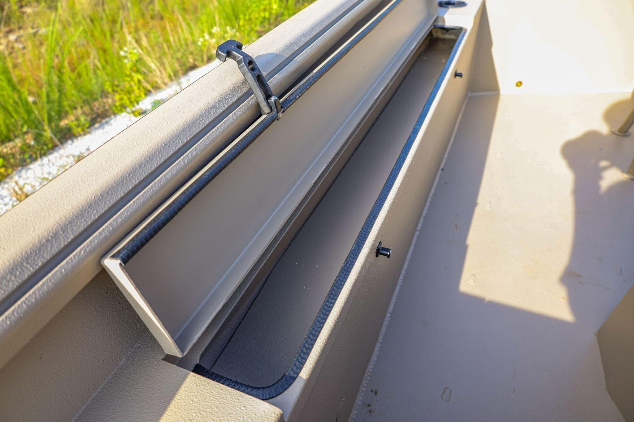 2026 Excel Switchblade boat storage compartment with open lid, showcasing interior space.