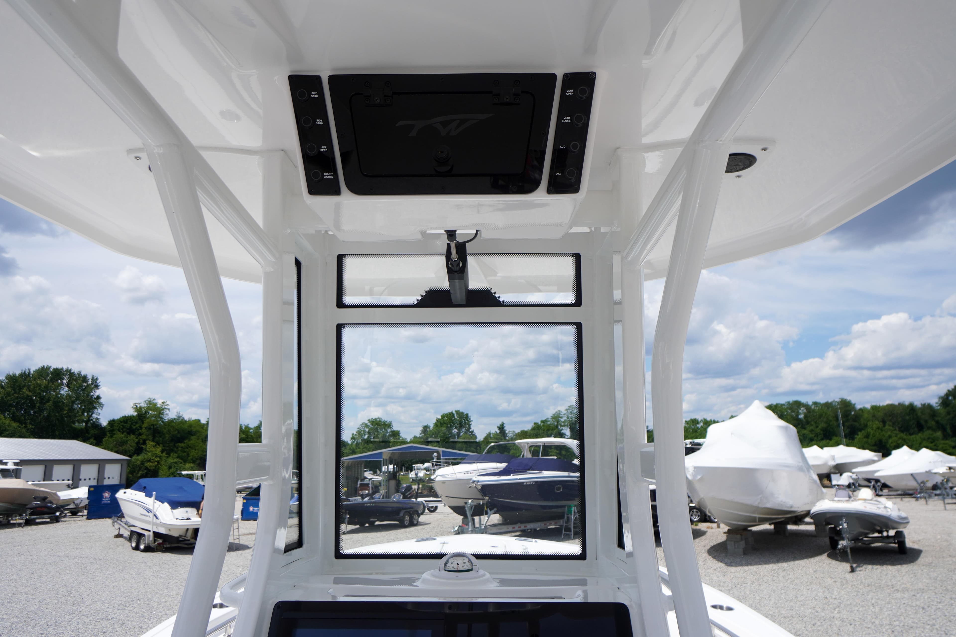 2026 Tidewater 232 SS boat interior with clear view of marina and sky.