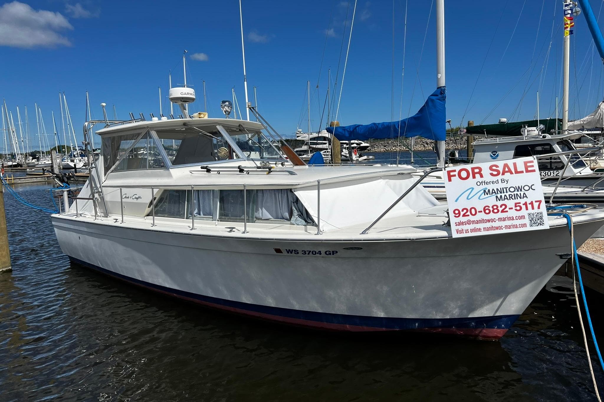 1967 Chris-Craft 31 Commander boat for sale at marina, clear sky background.