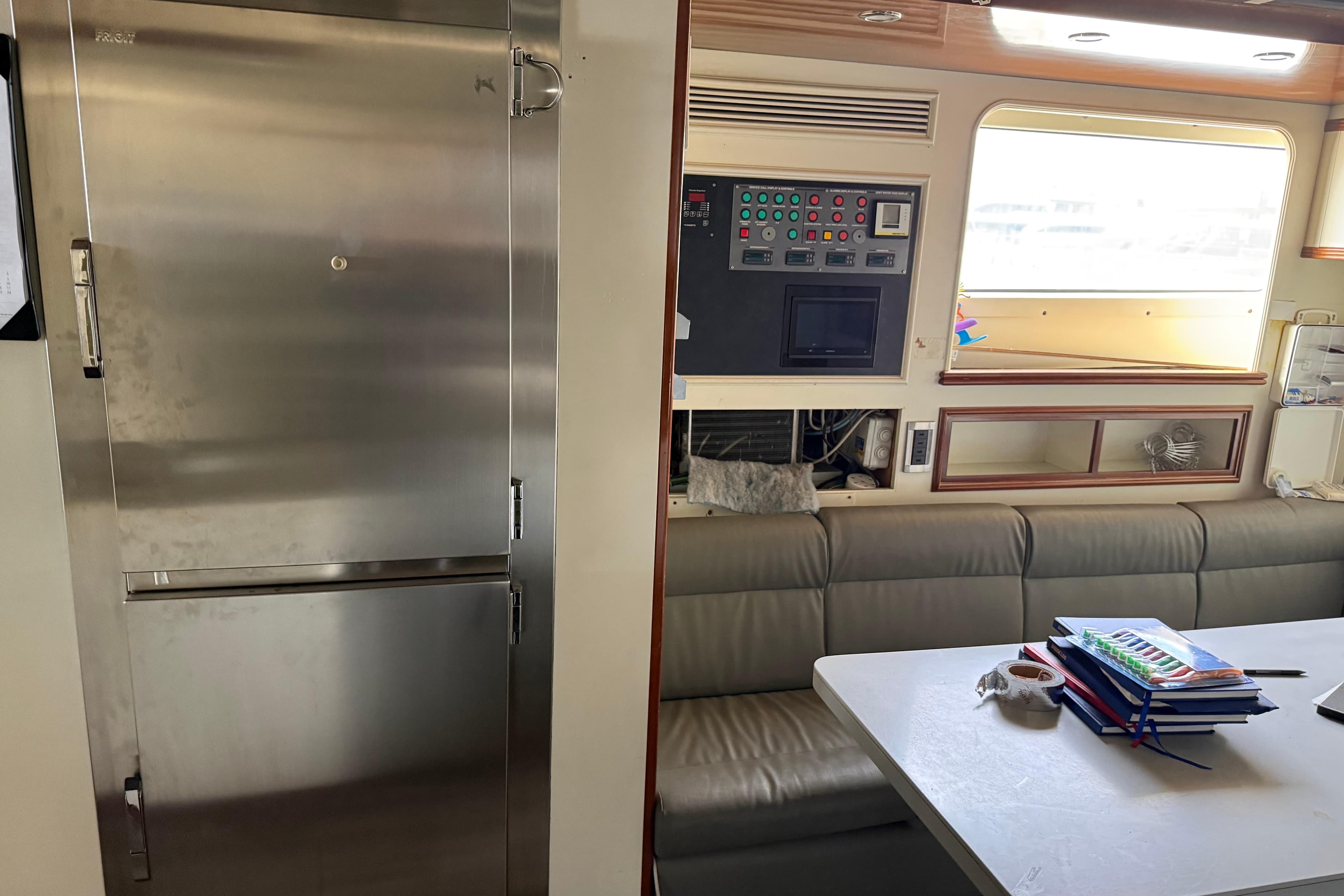 Interior of 2003 Benetti Classic 115 yacht with stainless steel fridge and control panel.