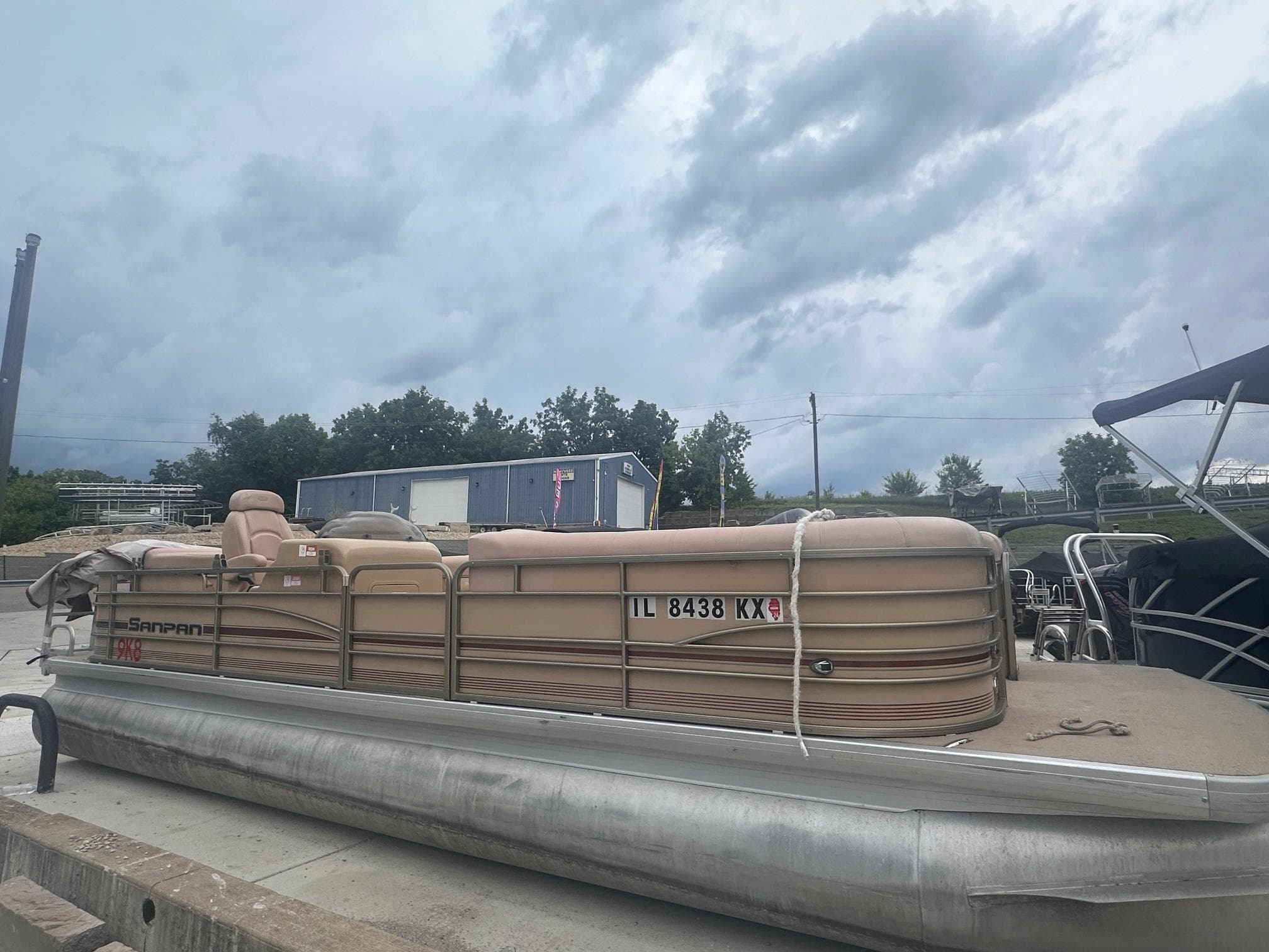 2008 Godfrey Sanpan 2500 RE pontoon boat docked under cloudy sky.