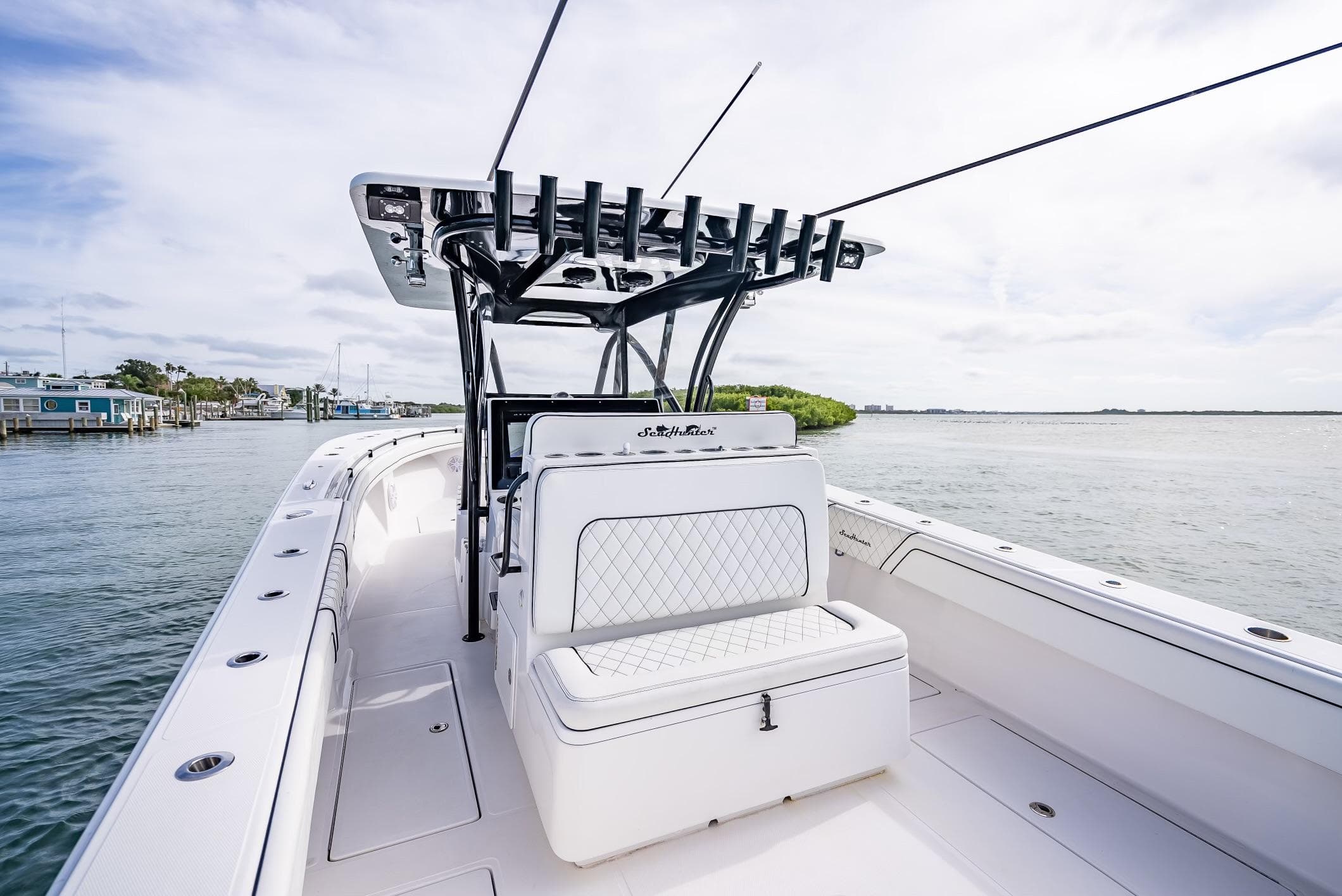 2020 SeaHunter 35 Tournament boat with white seating and rod holders on a calm waterway.